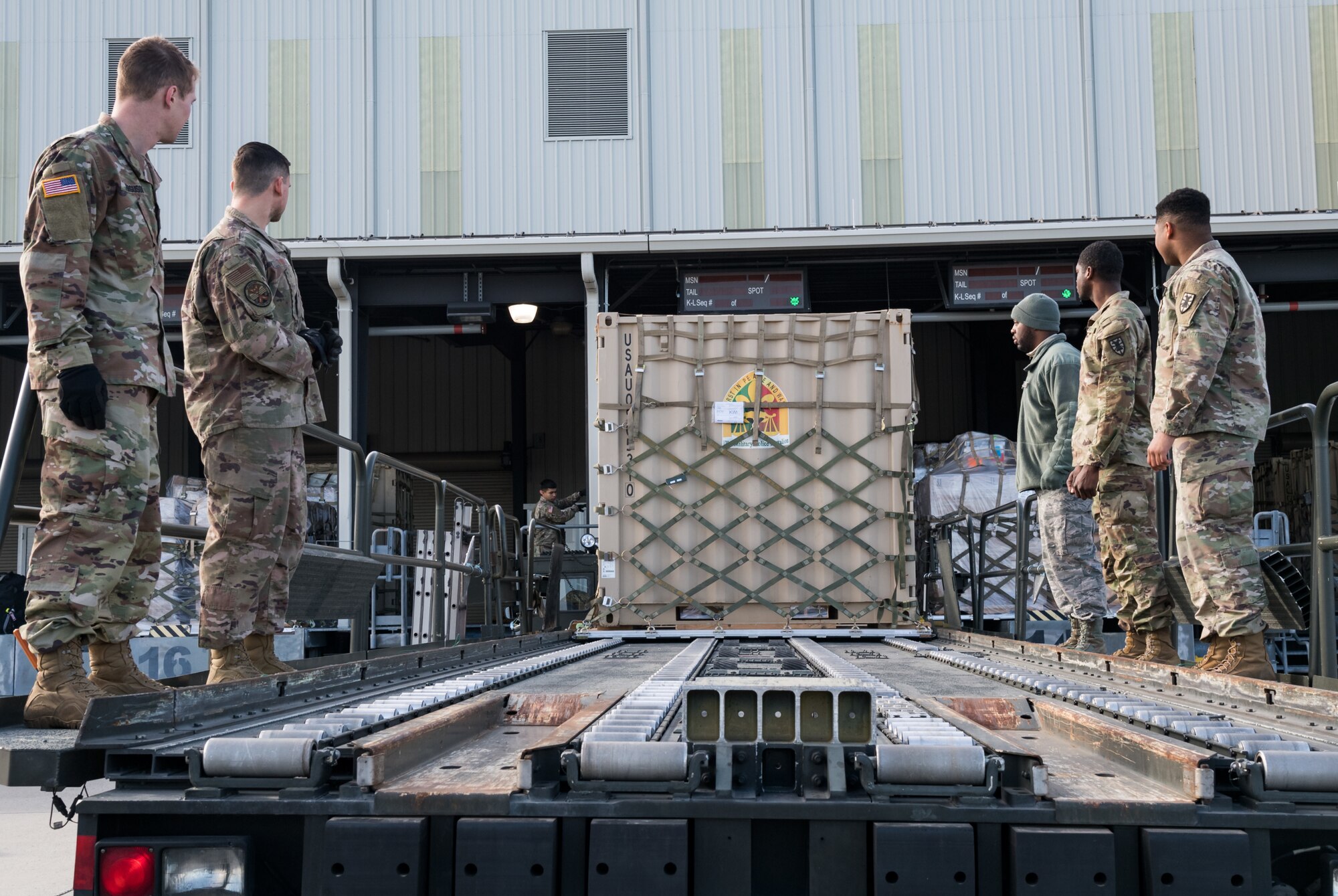 Members of the 436th Aerial Port Squadron, Dover Air Force Base, Del., and Army’s 622nd Movement Control Team, Joint Base Langley-Eustis, Va., observe a pallet being loaded onto a 60-ton K-loader Jan. 10, 2020, on Dover AFB. In a scheduled joint partnership training event, 16 members from the 622nd MCT came to Dover AFB for cargo and personnel processing training. (U.S. Air Force photo by Roland Balik)