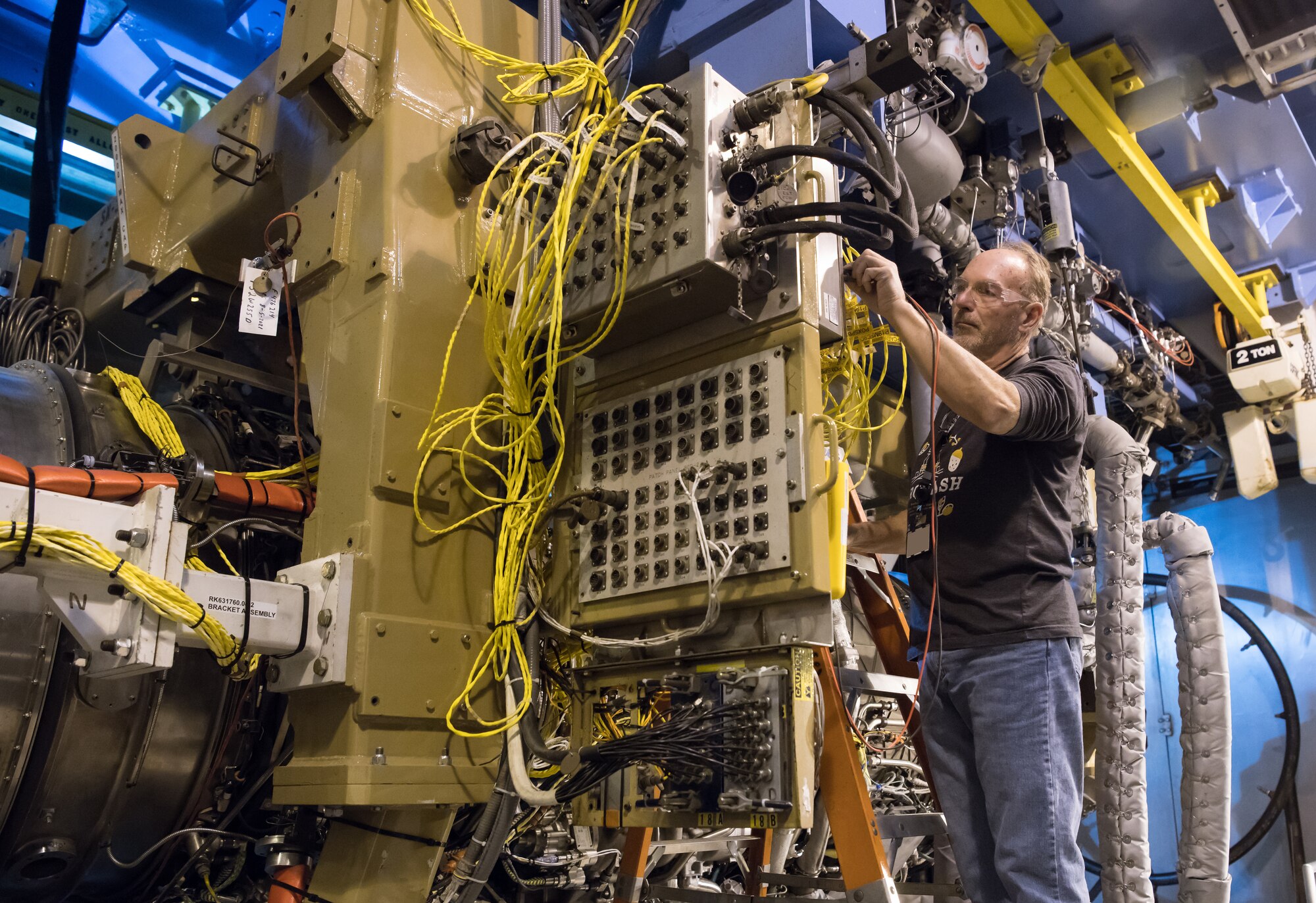 Scott Degenhardt, an instrument technician, uses a multimeter while checking equipment in an Arnold Engineering Development Complex Engine Test Facility test cell at Arnold Air Force Base between test runs of an F135 engine. The F135 is undergoing Accelerated Mission Testing in the AEDC facility and is used to power the F-35 Joint Strike Fighter Lightning II. (U.S. Air Force photo by Jill Pickett)(This image was altered by obscuring a badge for security purposes)