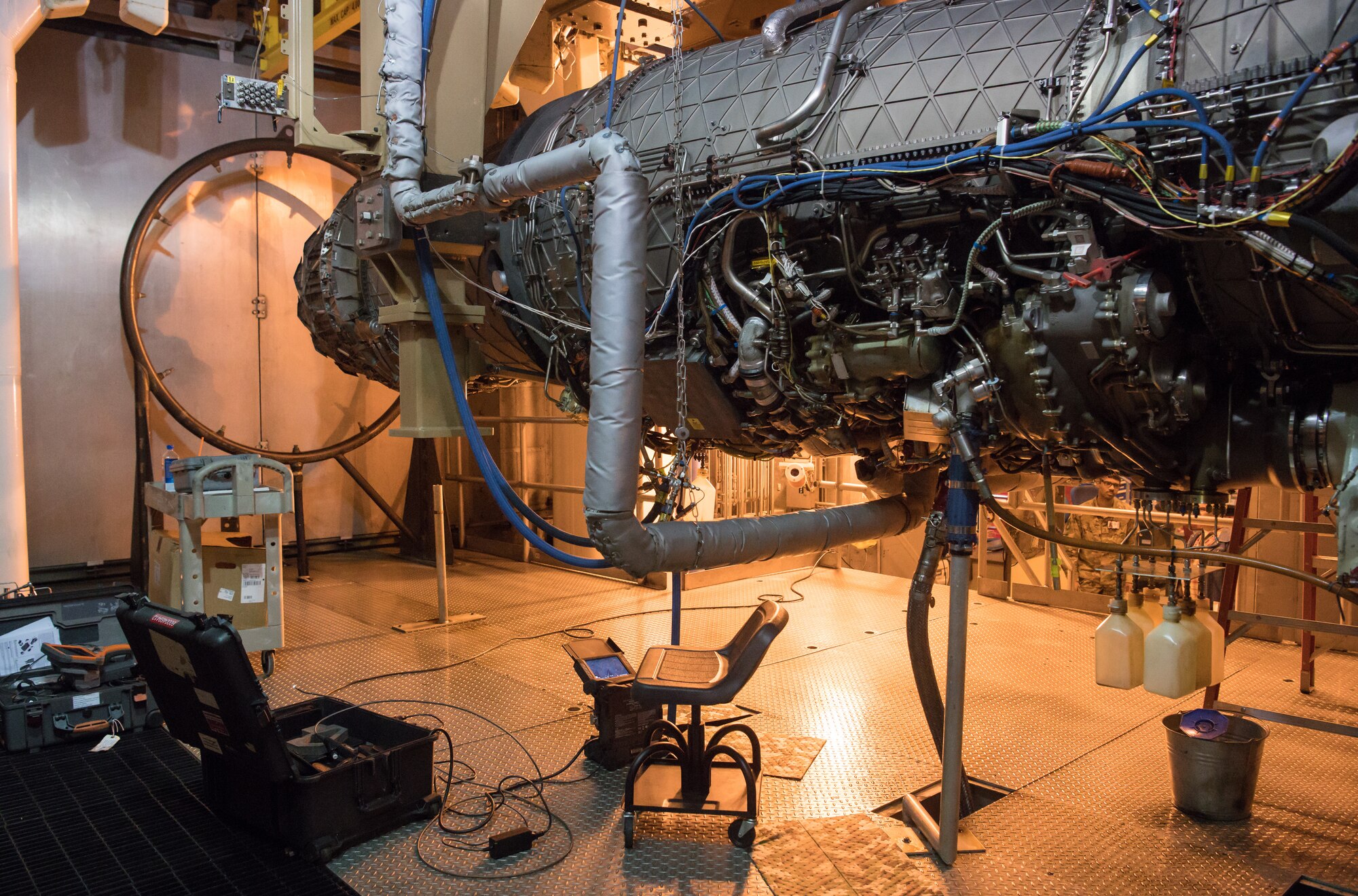 A scope sits below an F135 engine ready to be used by a technician to inspect interior elements of the engine in an Arnold Engineering Development Complex Engine Test Facility test cell at Arnold Air Force Base between test runs. The F135 is undergoing Accelerated Mission Testing in the AEDC facility and is used to power the F-35 Joint Strike Fighter Lightning II. (U.S. Air Force photo by Jill Pickett)