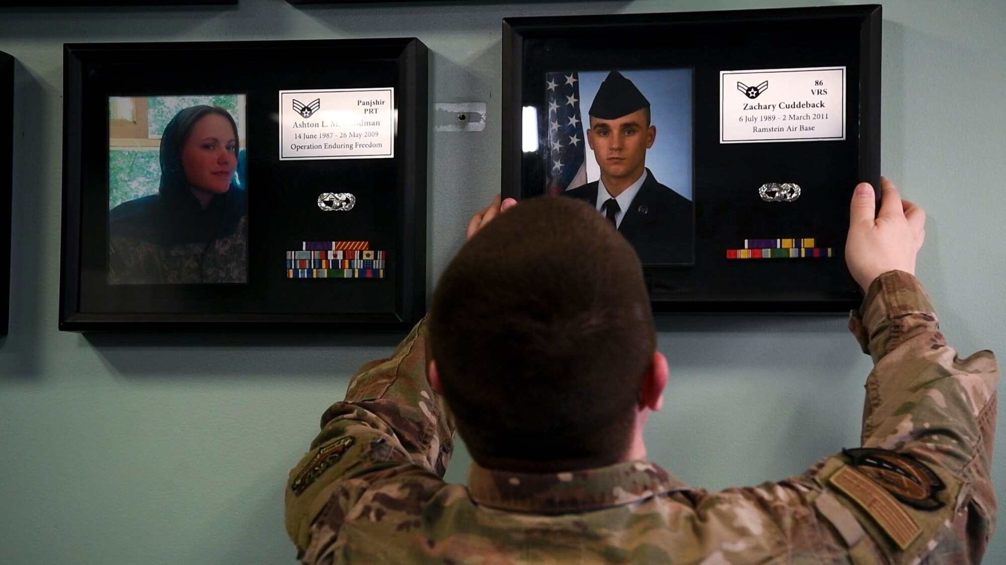 Senior Airman Matthew Chandler, 436th Logistics Readiness Squadron ground transportation operator, places a shadow box on the wall Jan. 17, 2020, at Dover Air Force Base, Del. Chandler was stationed at Ramstein Air Base, Germany with Airman 1st Class Zachary Cuddeback, 86th Vehicle Readiness Squadron, who was killed in the line of duty. (U.S. Air Force photo by Senior Airman Christopher Quail)
