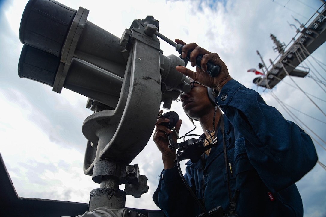 A sailor keeps watch on a ship.