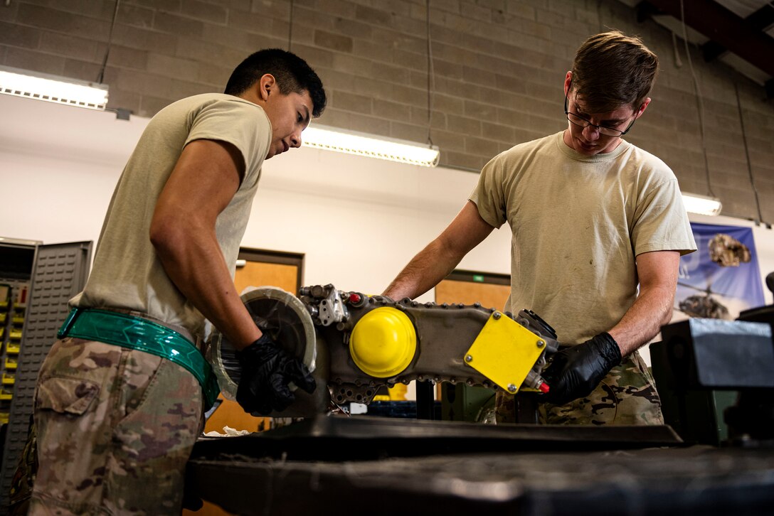 Staff Sgt. Leon Blomeley, right, 41st Helicopter Maintenance Unit craftsman, and Airman 1st Class Jonathan Flores, 41st HMU apprentice, position a gearbox during a gearbox seal replacement on a spare HH-60G Pave Hawk engine Jan. 15, 2020, at Moody Air Force Base, Georgia. These repairs are performed to increase spare-part availability of HH-60G engines. This allows the 41st HMU to swiftly return aircraft to mission-capable status without delay. (U.S. Air Force photo by Senior Airman Erick Requadt)