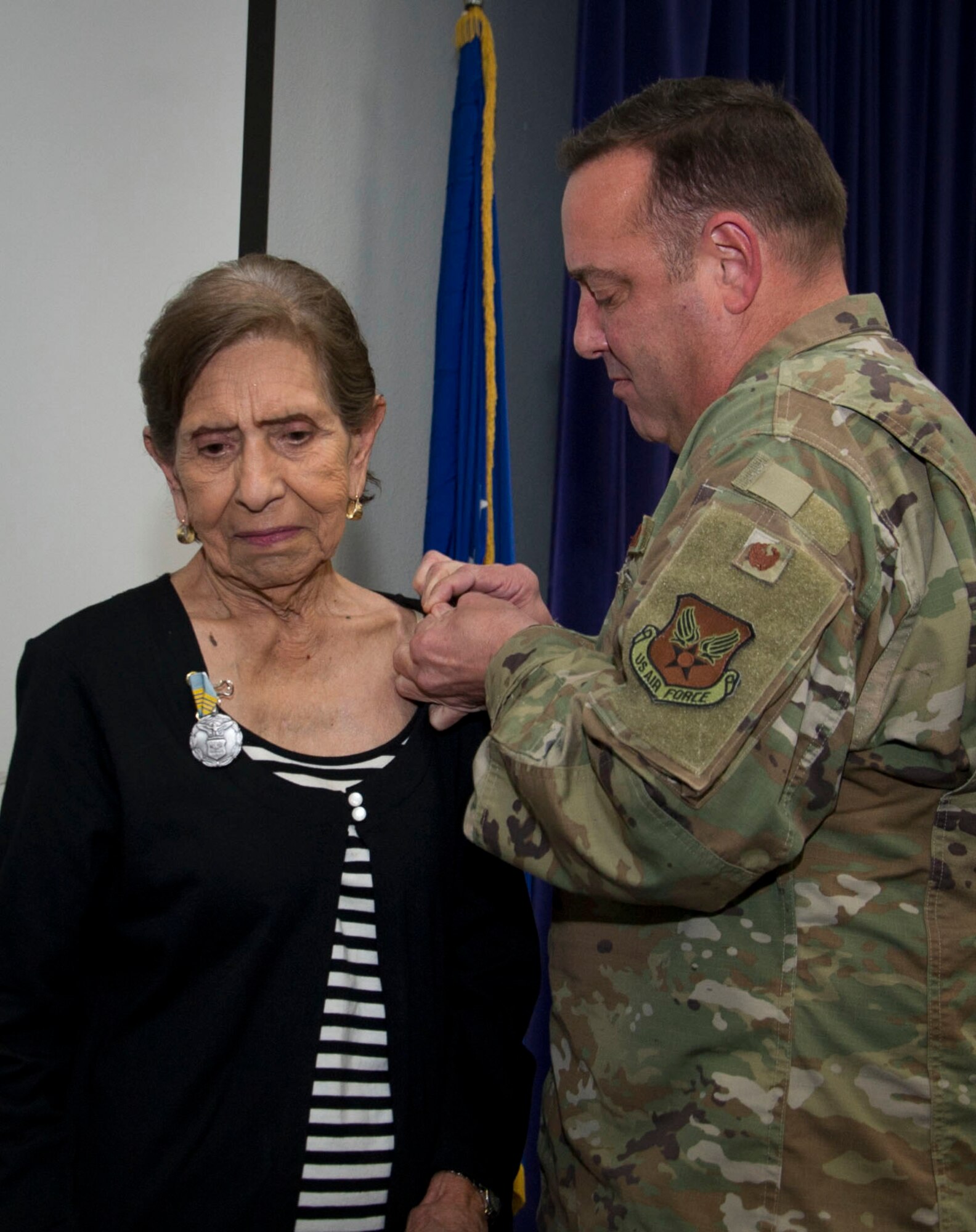Mary O. Price receives a pin for the Award for Meritorious Civilian Service during her retirement ceremony.