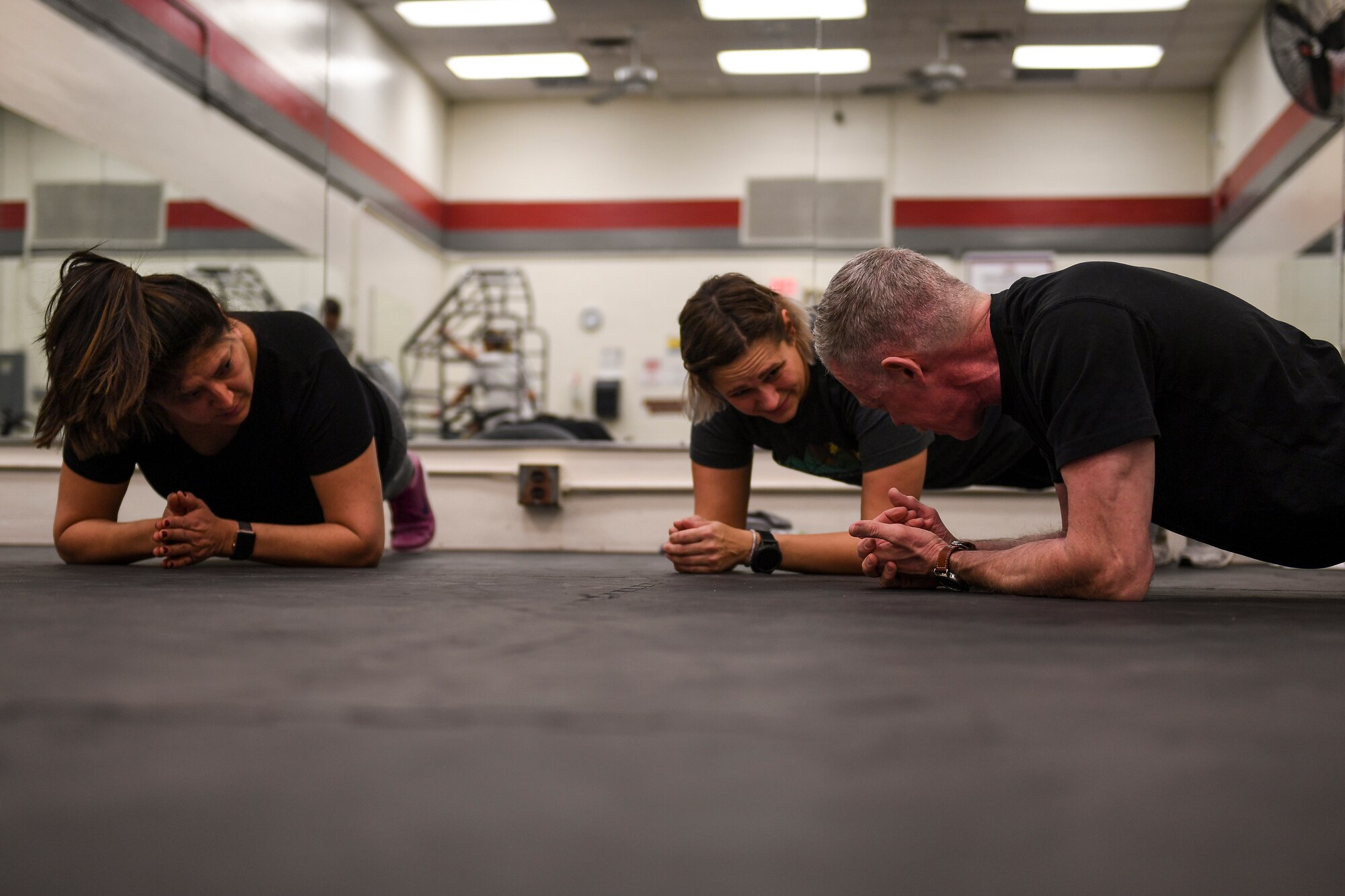 People perform the plank during a weight training class.
