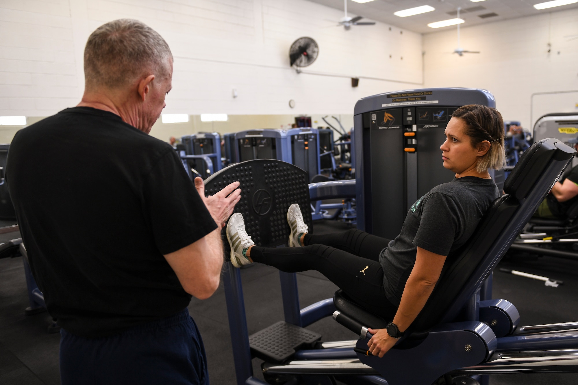 A person learns lifting techniques at a gym.