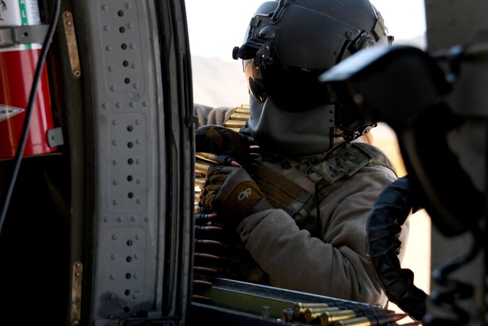 photo of an airman loading a .50 caliber machine gun for the HH-60