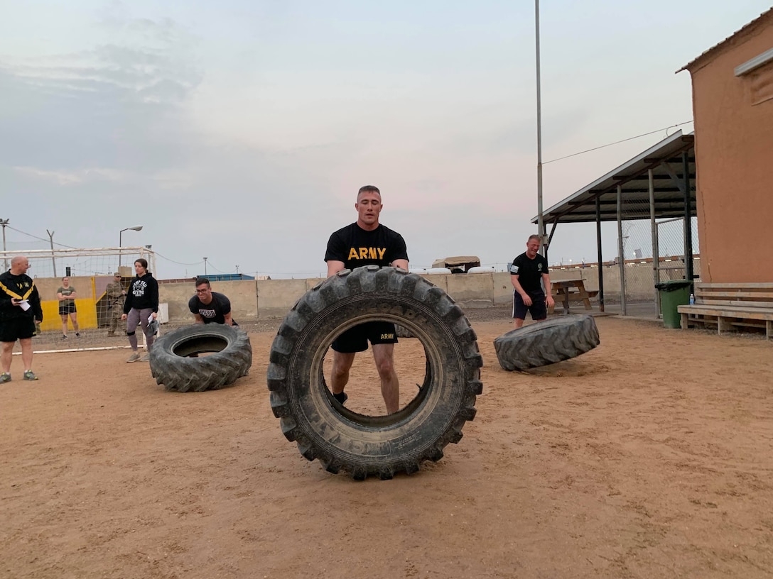 Soldiers flip large tires.