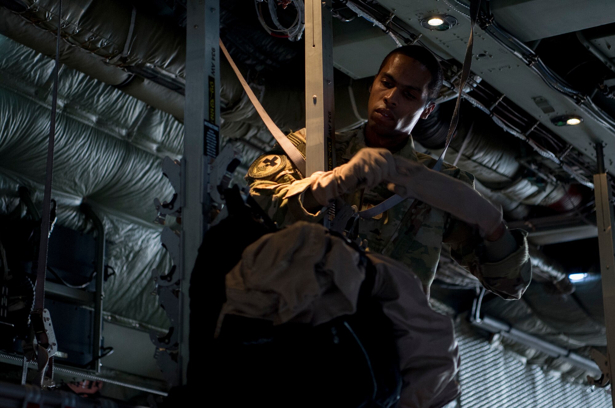 A U.S. Air Force medical technician assigned to the 379th Expeditionary Aeromedical Evacuation Squadron configures the inside of a C-130 Hercules during an aeromedical evacuation mission at Al Udeid Air Base, Qatar, Jan. 3, 2020.
