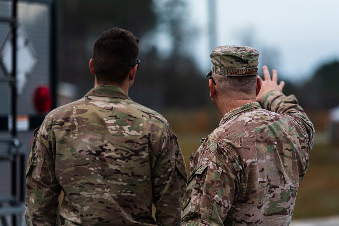 A photo of an Airman pointing toward a UXO
