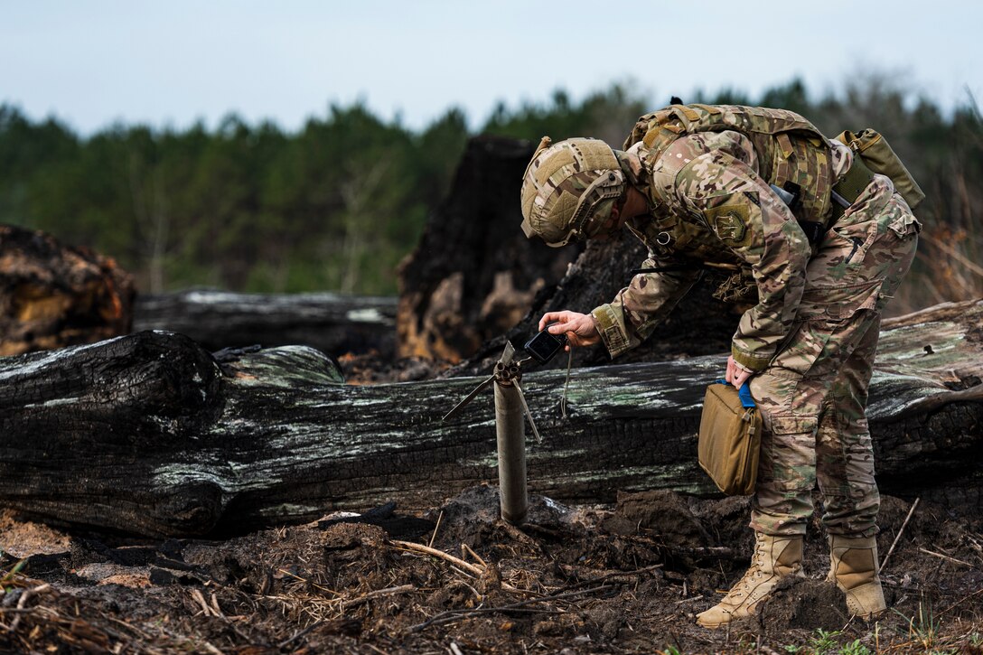 A photo of an Airman photographing a UXO