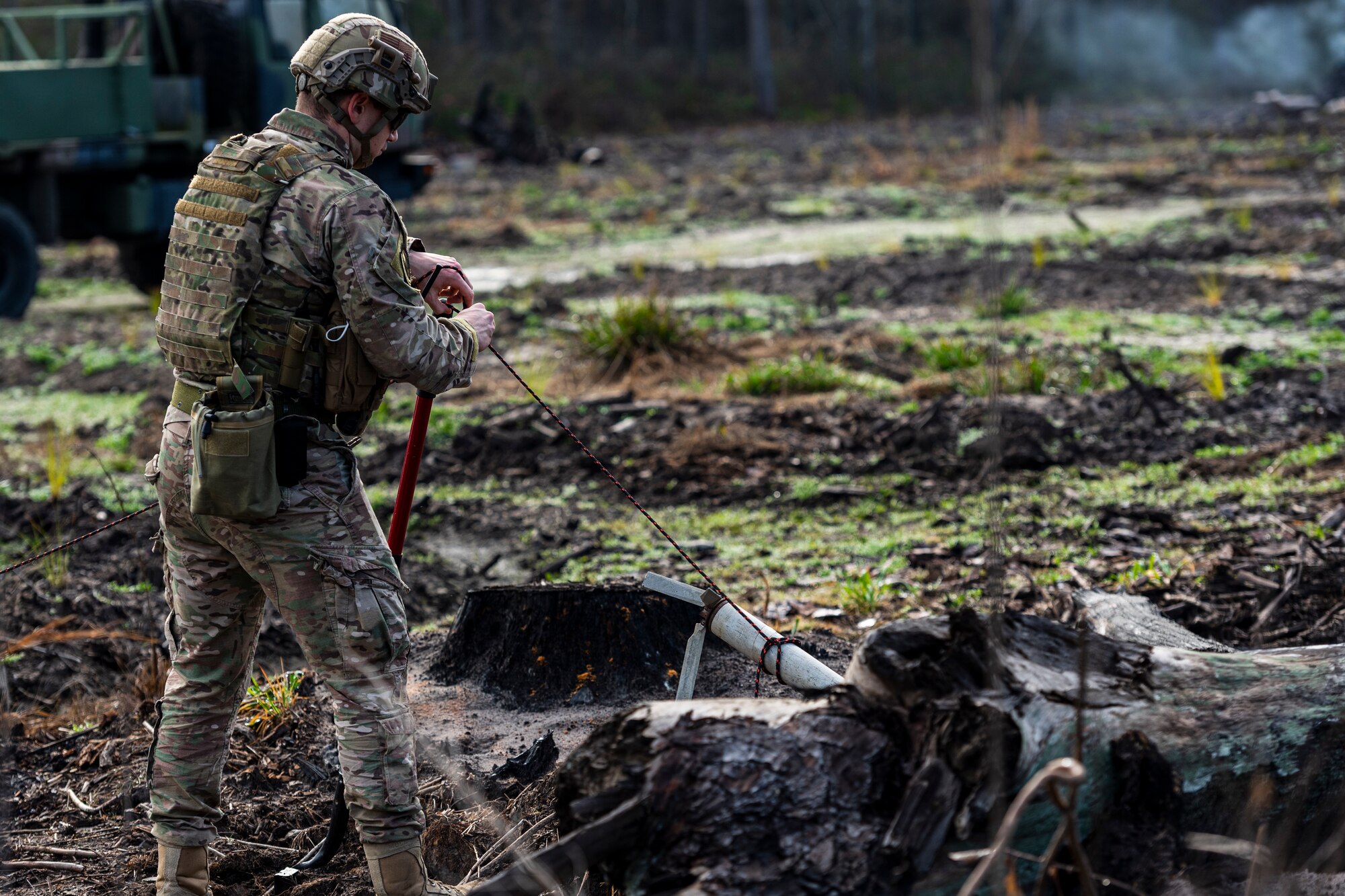 A photo of an Airman tying rope to a shovel