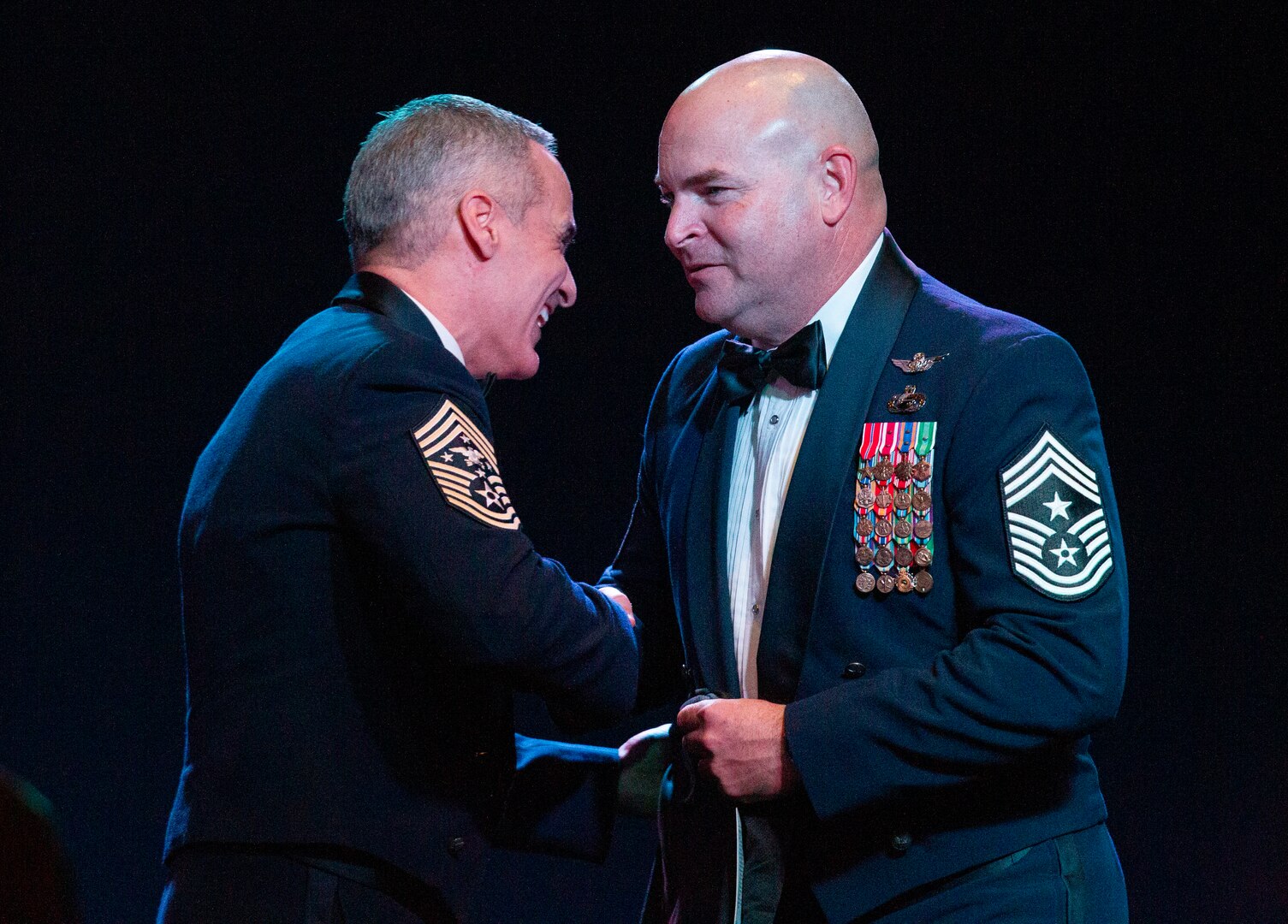 U.S. Air Force Command Chief Master Sgt. Thomas L. James, Senior Enlisted Advisor to the Adjutant General of the California Military Department, right, presents a custom California pararescue t-shirt to Senior Enlisted Advisor to the Chairman of the Joint Chiefs of Staff Ramón “CZ” Colón-López, left, after SEAC's keynote remarks during the California Military Department Service Member of the Year Banquet, Jan. 18, 2020, in San Diego. SEAC, himself a pararescueman, spent the day meeting with California National Guard Soldiers and Airmen during the Cal Guard's annual leadership conference. The California Air National Guard is home to the 129th Rescue Wing which has recorded more than a thousand lives saved.