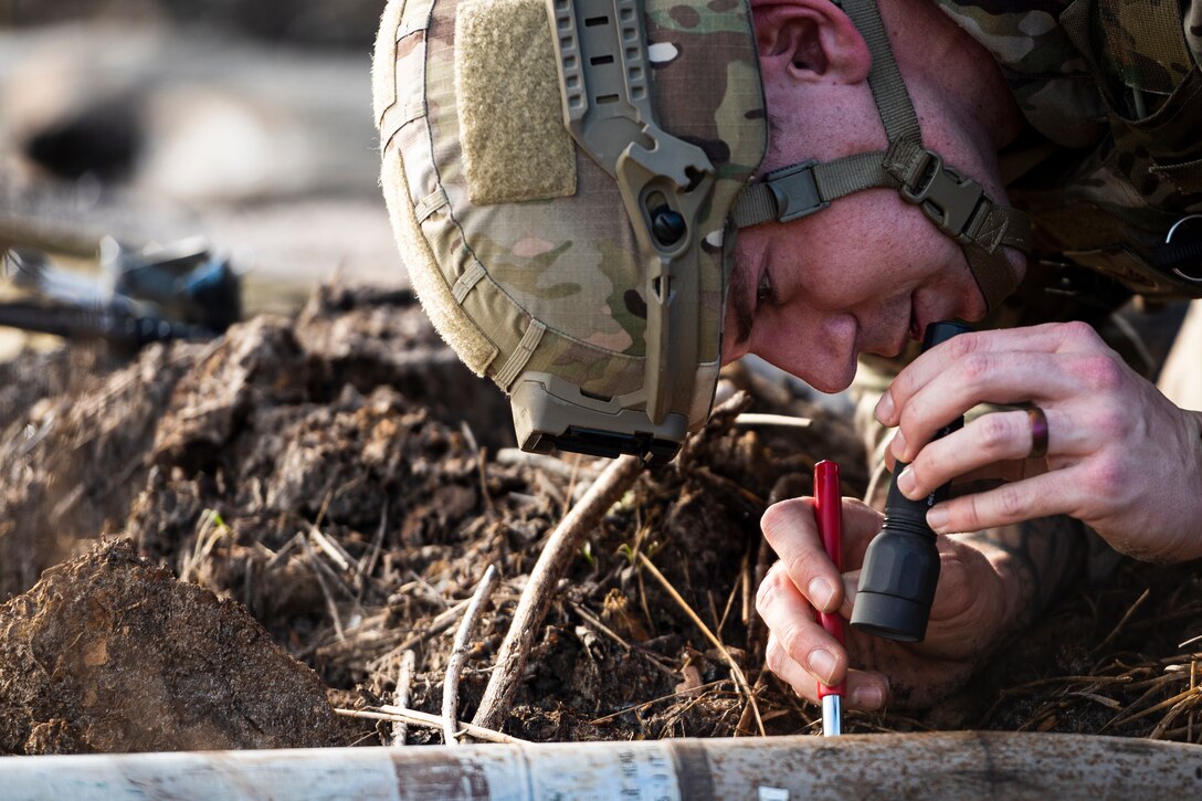 A photo of an Airman inspecting a UXO