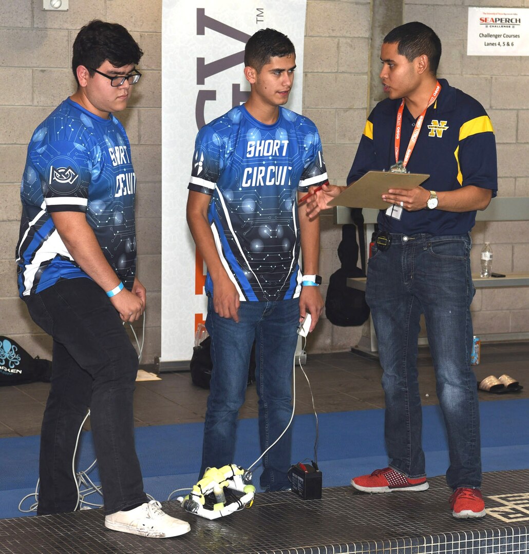 Petty Officer 2nd Class Jesus Escobar (right), assigned to Navy Recruiting Station McAllen, briefs Team Sparky of Harlingen Early College High School regarding the challenge course during the HESTEC 2020 SeaPerch Challenge held at the Margaret M. Clark Aquatic Center in Brownsville, Texas. The annual underwater robotics competition, hosted by the University of Texas Rio Grande Valley, in partnership with Navy Recruiting District San Antonio, kicked-off a new format to Hispanic Engineering, Science and Technology, or HESTEC, this year.