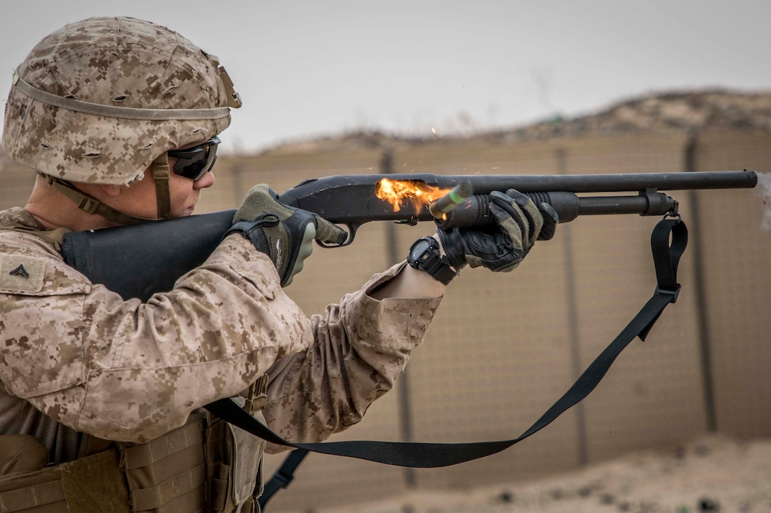 A Marine fires a shotgun.