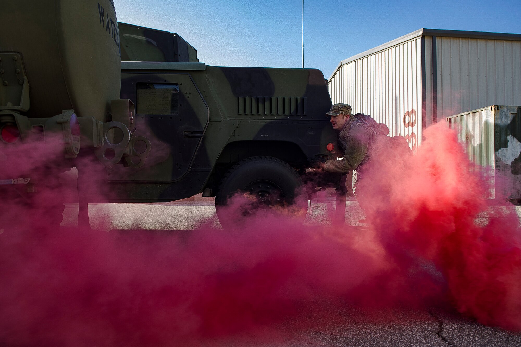 A 51st Security Forces Squadron defender pushes a Humvee through smoke during a physical training challenge as part of a Combat Readiness Course, Dec. 12, 2019, at Osan Air Base, Republic of Korea. The course challenges Osan’s newest defenders on their readiness and skills to defend the base. (U.S. Air Force photo by Staff Sgt. Greg Nash)