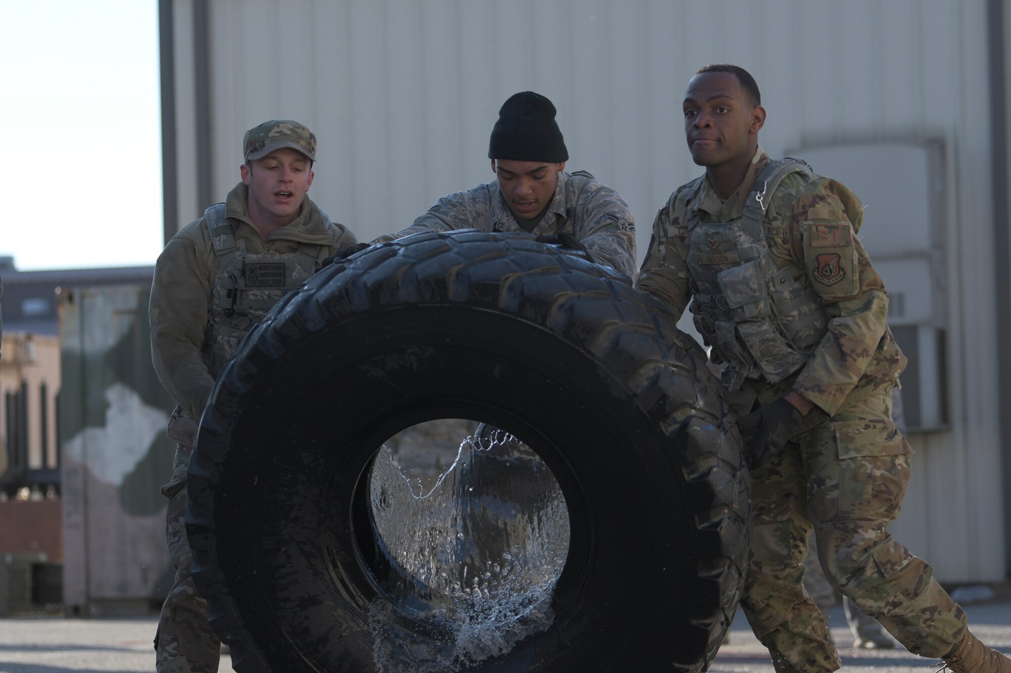 51st Security Forces Squadron defenders flip a tire during a physical training challenge as part of a Combat Readiness Course, Dec. 12, 2019, at Osan Air Base, Republic of Korea. The course challenges Osan’s newest defenders on their readiness and skills to defend the base. (U.S. Air Force photo by Staff Sgt. Greg Nash)