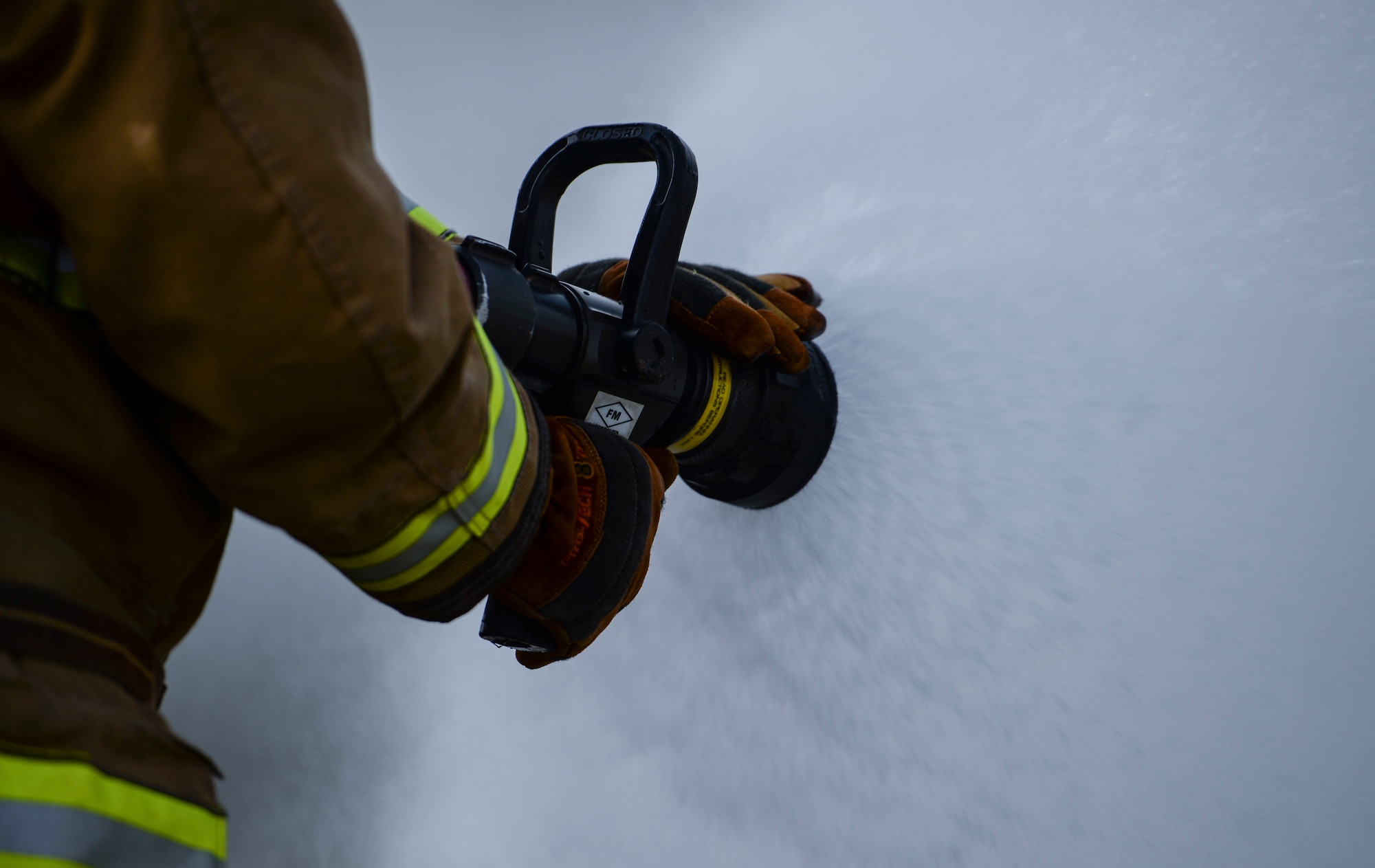 A firefighter assigned to the 36th Civil Engineer Squadron, Andersen Air Force Base, Guam sprays water on a live fire training burn, January 8, 2020, at AAFB.