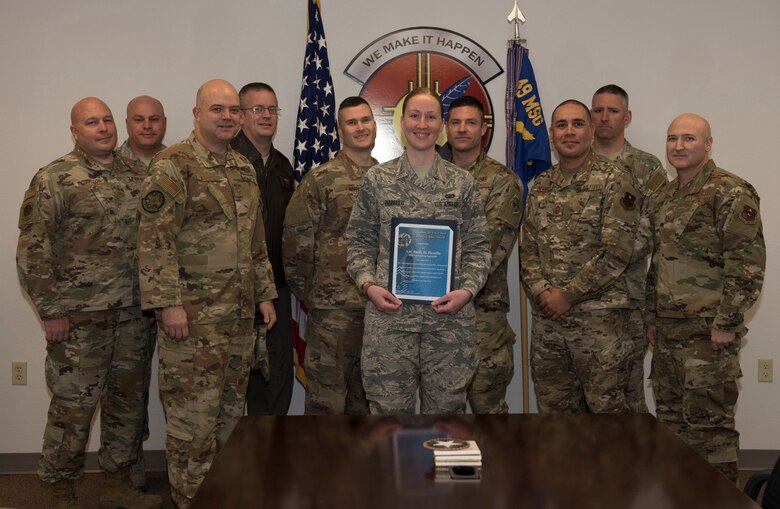 Airman 1st Class Emily H. Pizzello, 49th Contracting Squadron contract administrator and representatives from the Holloman Air Force Base’s Chiefs Group pose with during a group photo Jan 21, 2019, on Holloman Air Force Base, N.M. Holloman’s Chiefs Group has a monthly recognition program titled Chief’s Choice Award, and every month a chief has the honor of choosing a deserving Airman for an outstanding act or for continuous outstanding performance. (U.S. Air Force photo by Staff Sgt. Christine Groening)