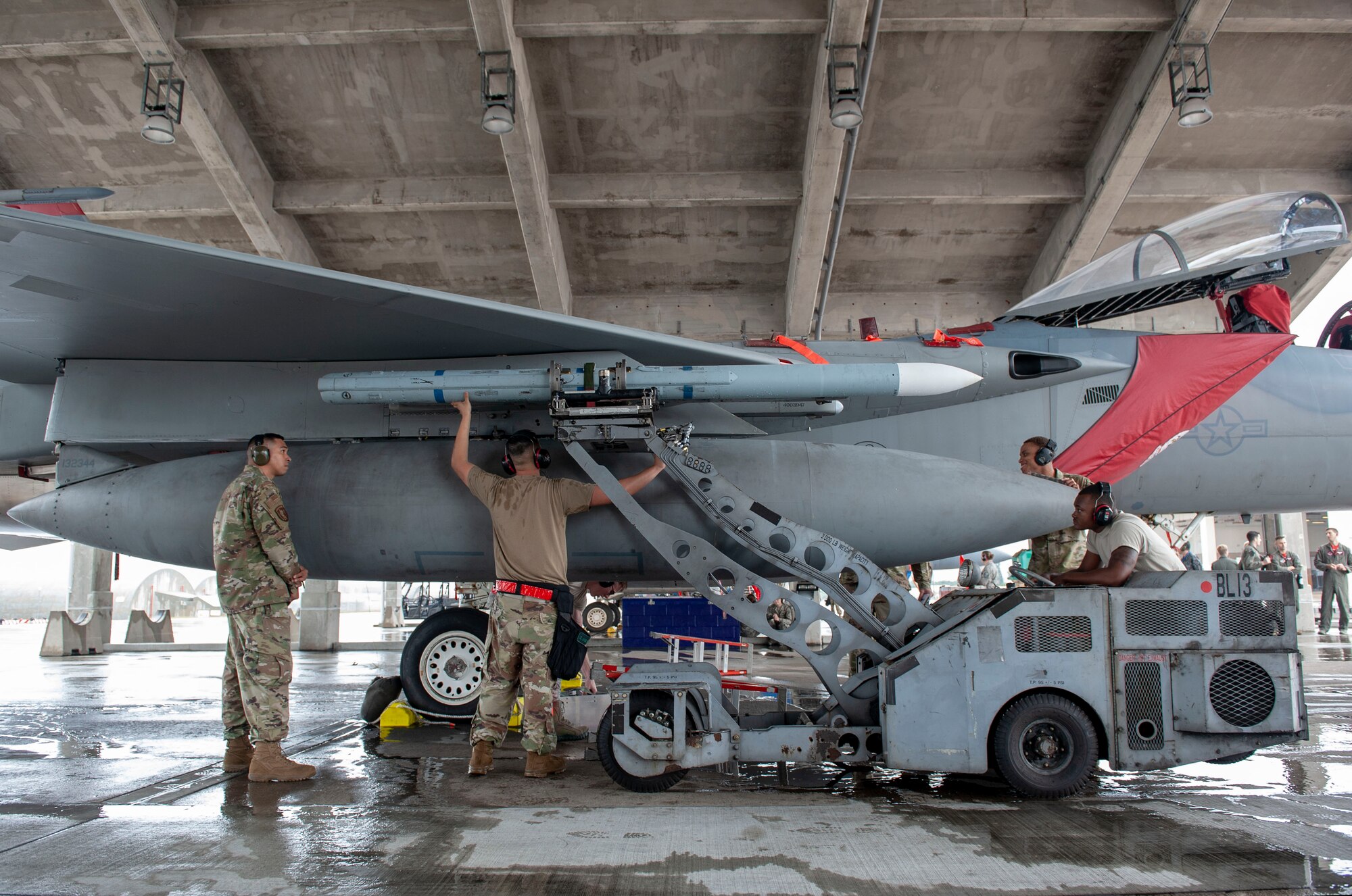 U.S. Air Force load crew members from the 67th Aircraft Maintenance Unit attaches an AIM-120 advanced medium-range air-to-air missile onto an F-15C Eagle during the annual weapons load competition at Kadena Air Base, Japan, Jan. 17, 2020. This event is a loading competition between weapons load crews from the 44th and 67th AMUs. Every year, the top weapons load crew team from each quarter competes for the annual Weapons Load Crew of the Year title. (U.S. Air Force photo by Naoto Anazawa)