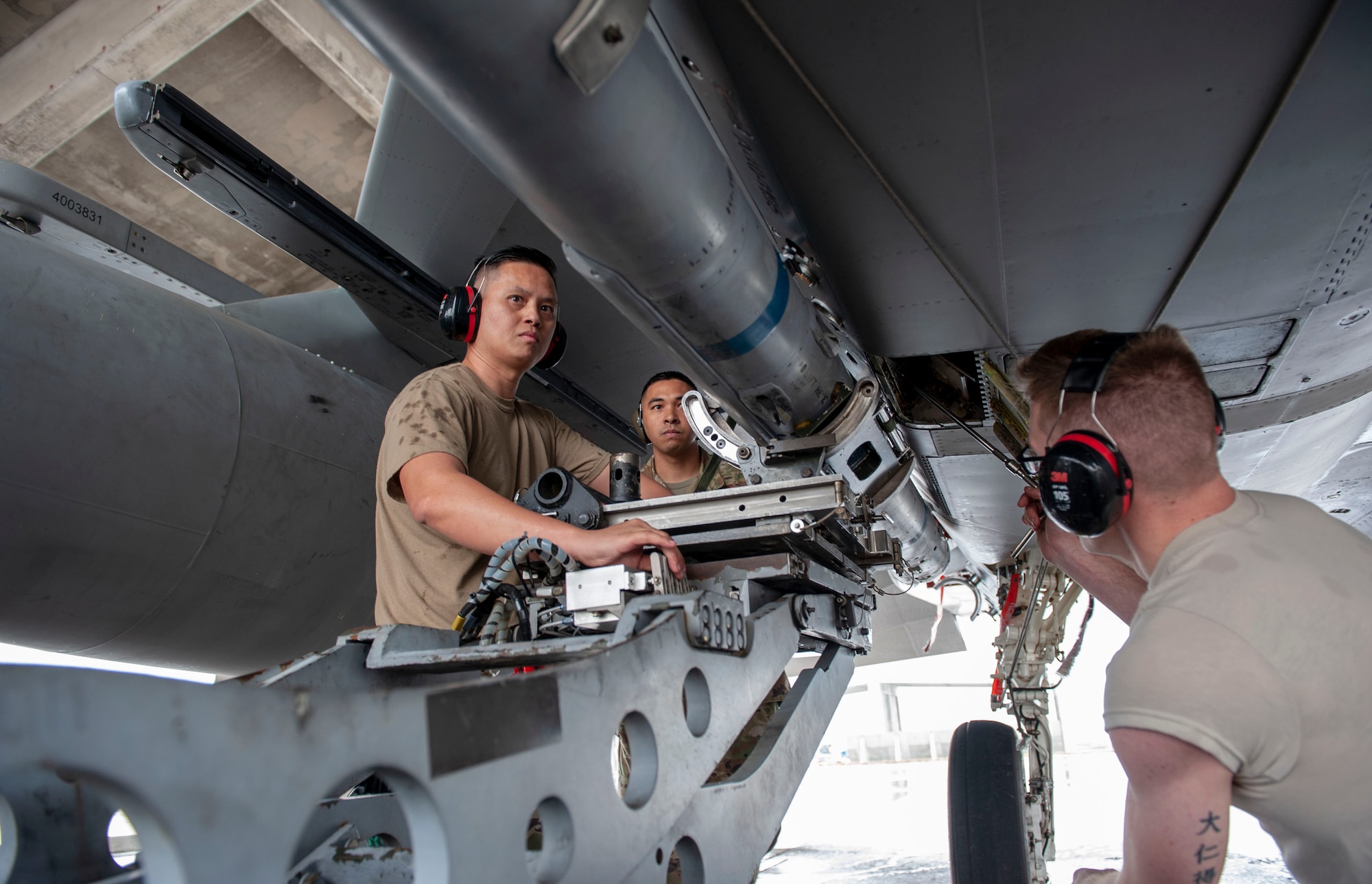 U.S. Air Force Staff Sgt. Chinh Nguyen (left), 67th Aircraft Maintenance Unit load crew chief, and Airman 1st Class Daniel Wolf (right), 67th AMU load crew member, secure an AIM-120 advanced medium-range air-to-air missile onto an F-15C Eagle aircraft during the annual weapons load competition at Kadena Air Base, Japan, Jan. 17, 2020. Each team must load the munition onto an F-15C Eagle aircraft with speed and precision. (U.S. Air Force photo by Naoto Anazawa)