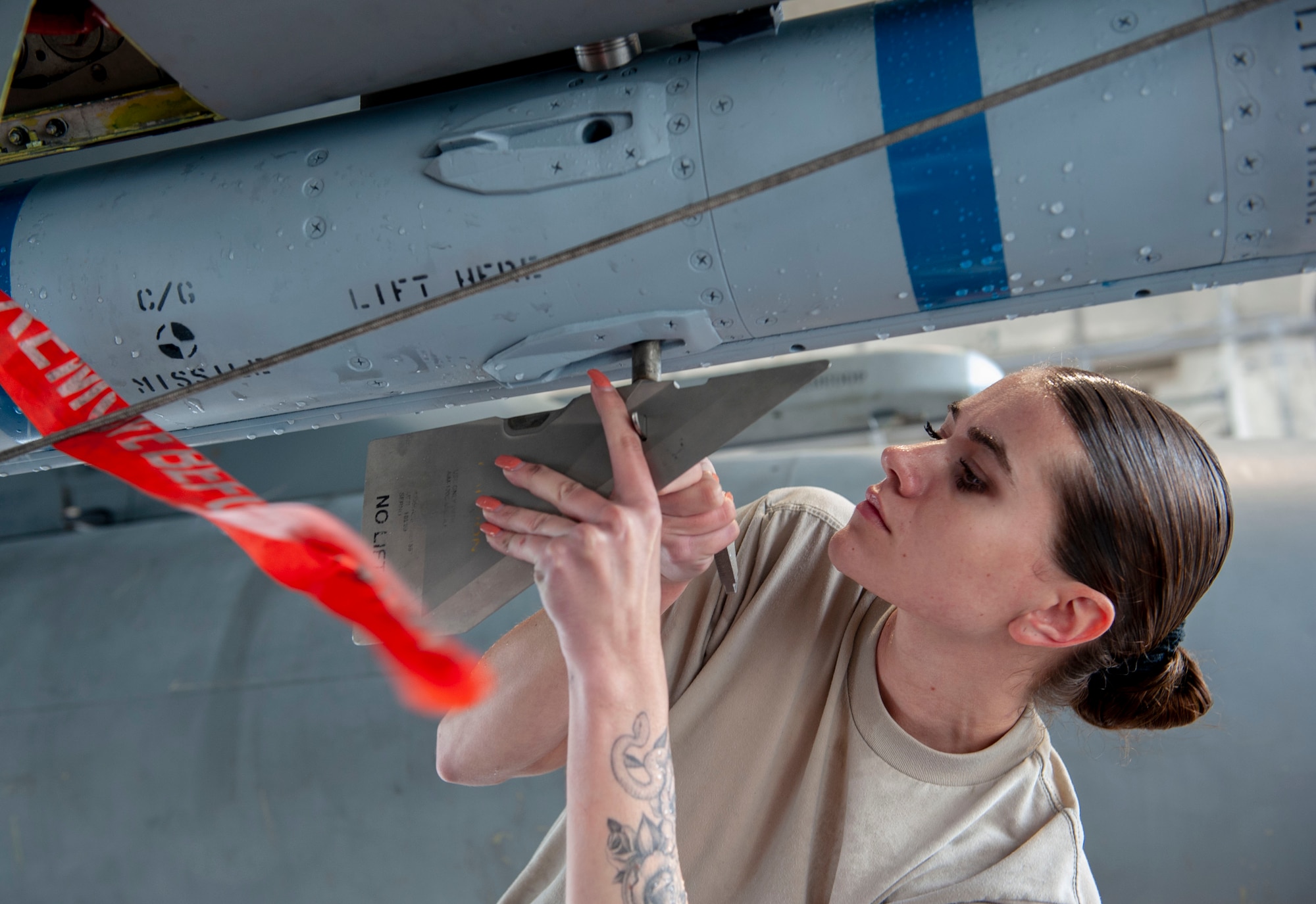 U.S. Air Force Airman 1st Class Amanda Allocca, 67th Aircraft Maintenance Unit load crew member, attaches the blade of an AIM-120 advanced medium-range air-to-air missile during the annual weapons load competition at Kadena Air Base, Japan, Jan. 17, 2020. Each team must load the munition onto an F-15C Eagle aircraft with speed and precision. (U.S. Air Force photo by Naoto Anazawa)