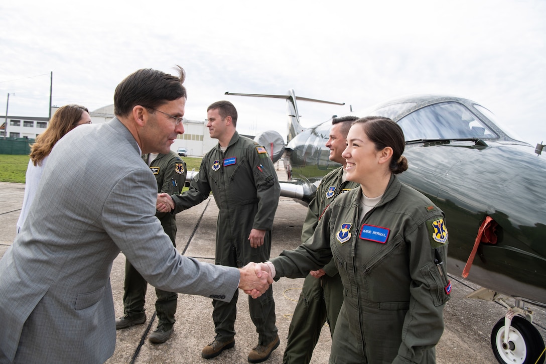 Defense Secretary Dr. Mark T. Esper shakes hands with instructors and students.