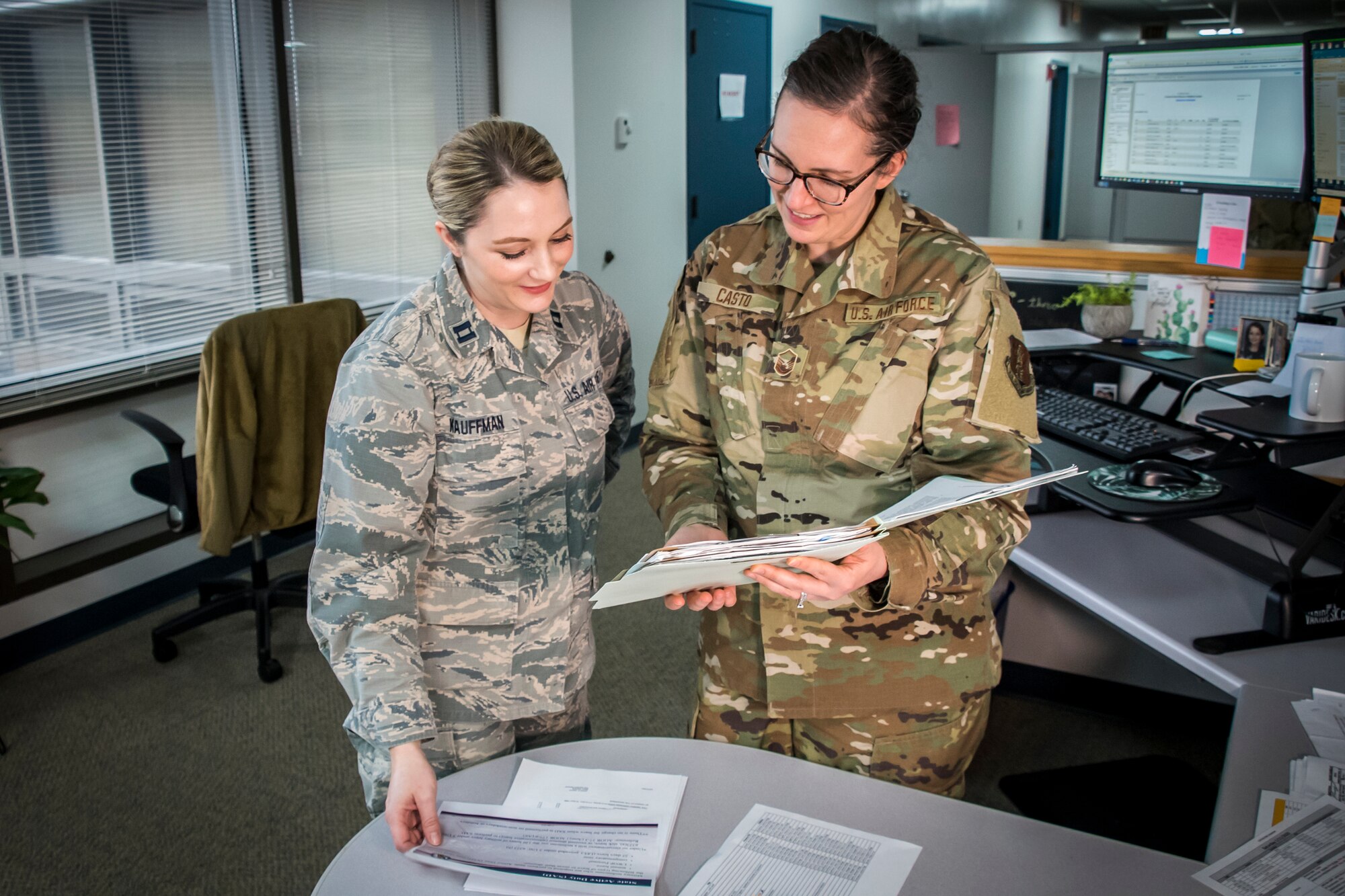 Air Force members look over documents in the Force Support Squadron office.