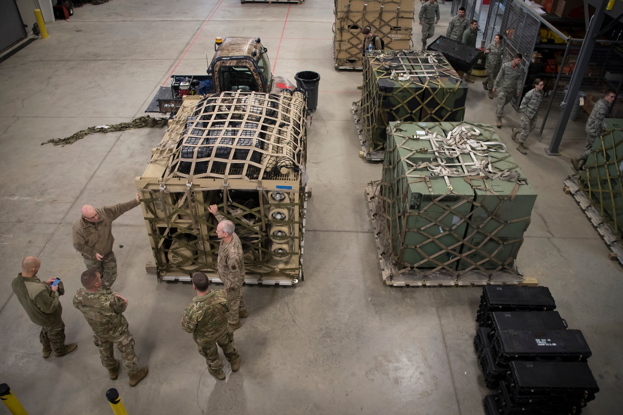 Photo of members packing equipment and preparing to load pallets on aircraft.
