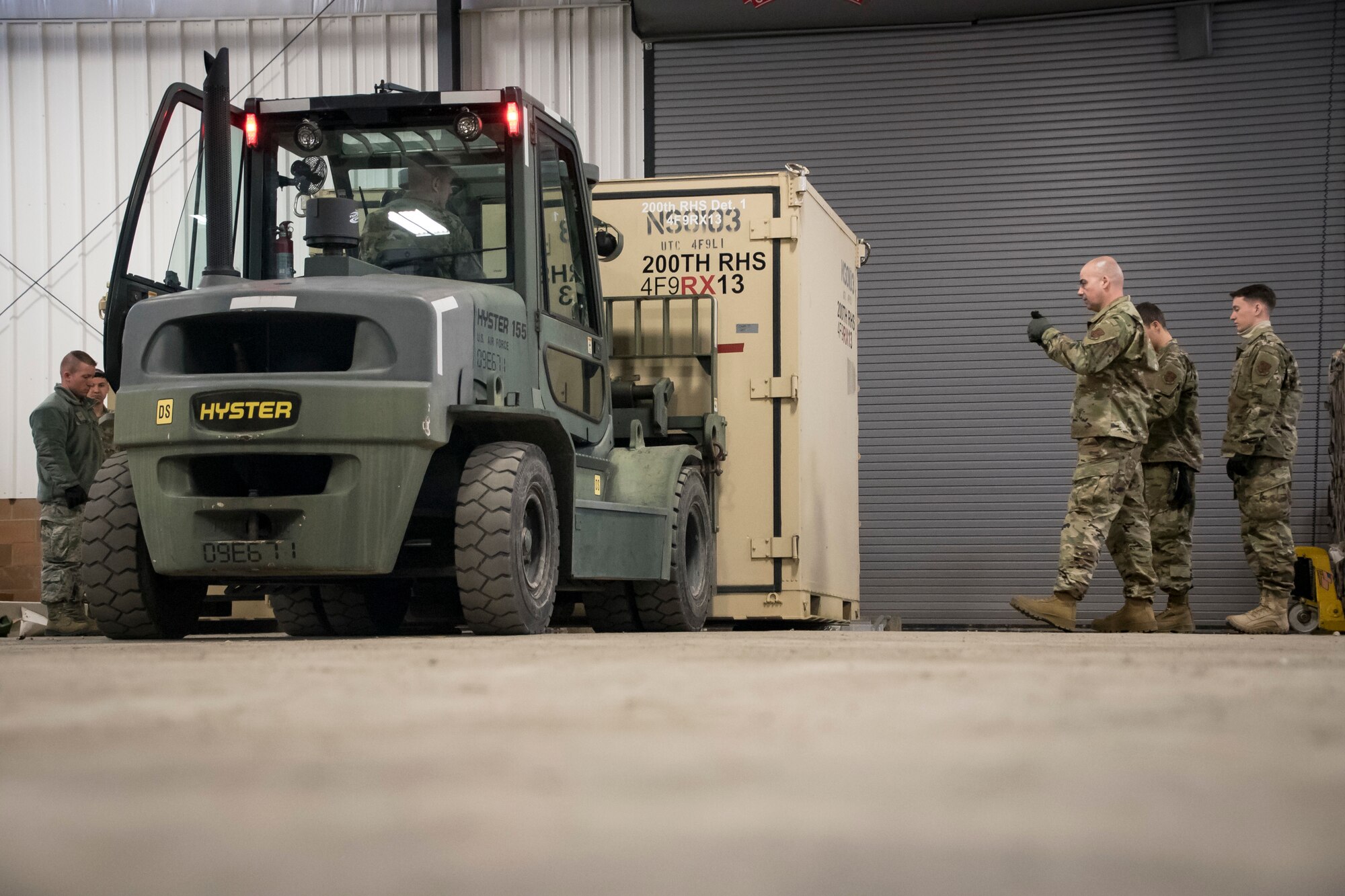 Photo of members packing equipment and preparing to load pallets on aircraft.