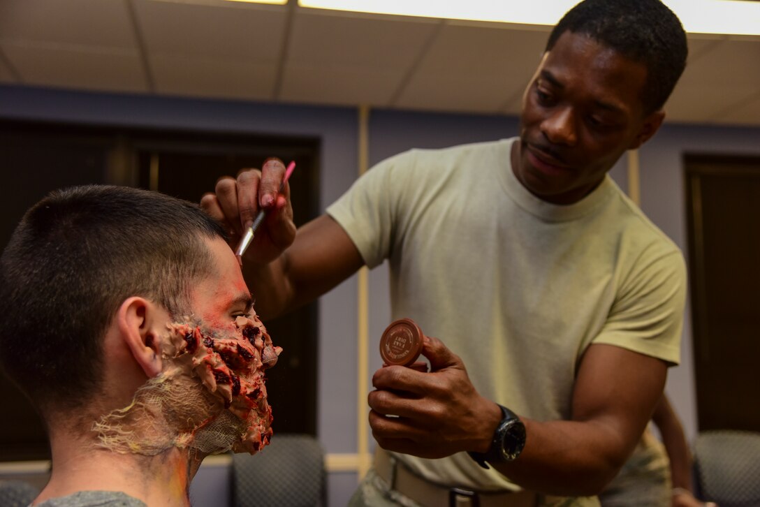 Staff Sgt. Gaetan President, a 47th Healthcare Operations Squadron laboratory technician, paints moulage on a volunteer patient before the Ready Eagle exercise, Jan. 17, 2020, at Laughlin Air Force Base, Texas. Each volunteer patient displays different injuries which might be seen in the event of an explosion. (U.S. Air Force photo by Senior Airman Anne McCready)