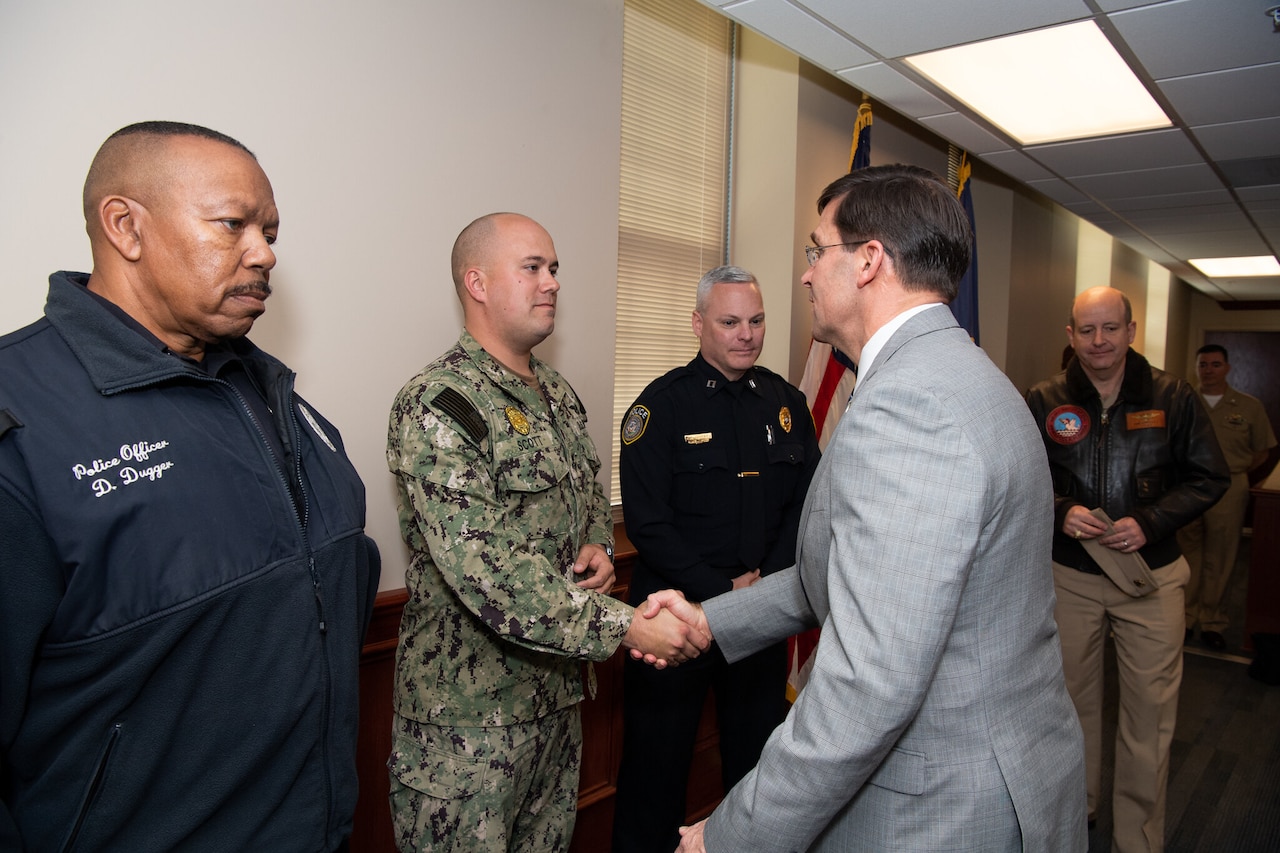 Two men shake hands.