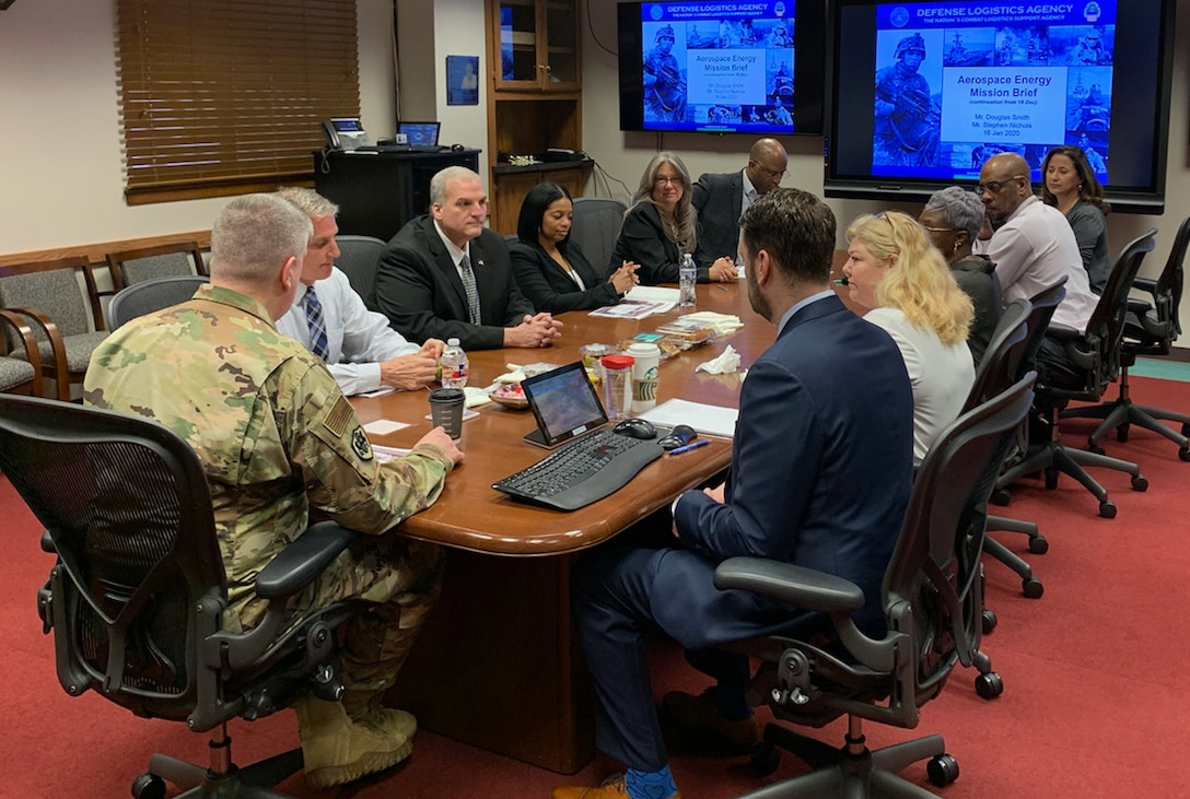 military and civilian people sit around a table