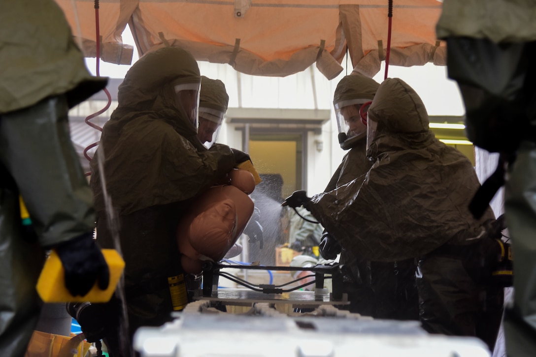 47th Medical Group medics wearing powered, air-purified respirator suits tend to a simulated patient in the in-place patient decontamination tent on Jan. 17, 2020 at Laughlin Air Force Base, Texas. In the event of a chemical, biological, radiological or nuclear disaster, patients who come to the clinic for care would have to go through this cleansing process before being admitted to the clinic. (U.S. Air Force photo by Senior Airman Anne McCready)