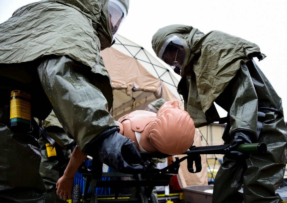 Two medics lower a stretcher with a simulated patient after being cleansed at the in-place patient decontamination tent during the Ready Eagle exercise on Jan. 17, 2020 at Laughlin Air Force Base, Texas. According to 1st Lt. Gabriel Lazurka, 47th Healthcare Operations Squadron medical logistics flight commander, they used the crawl-walk-run philosophy while training, practicing faster response times and exploring what the group can improve. (U.S. Air Force photo by Senior Airman Anne McCready)