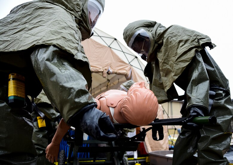 Two medics lower a stretcher with a simulated patient after being cleansed at the in-place patient decontamination tent during the Ready Eagle exercise on Jan. 17, 2020 at Laughlin Air Force Base, Texas. According to 1st Lt. Gabriel Lazurka, 47th Healthcare Operations Squadron medical logistics flight commander, they used the crawl-walk-run philosophy while training, practicing faster response times and exploring what the group can improve. (U.S. Air Force photo by Senior Airman Anne McCready)