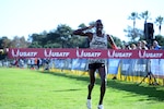 Army Cpl. Anthony Rotich salutes just before crossing the finish line to win the Armed Forces Cross Country Championship, run in conjunction with the USA Track and Field senior men 10K race at Mission Bay Park, San Diego, Calif., Jan. 18, 2020. Rotich took gold for both with a time of 30:36.