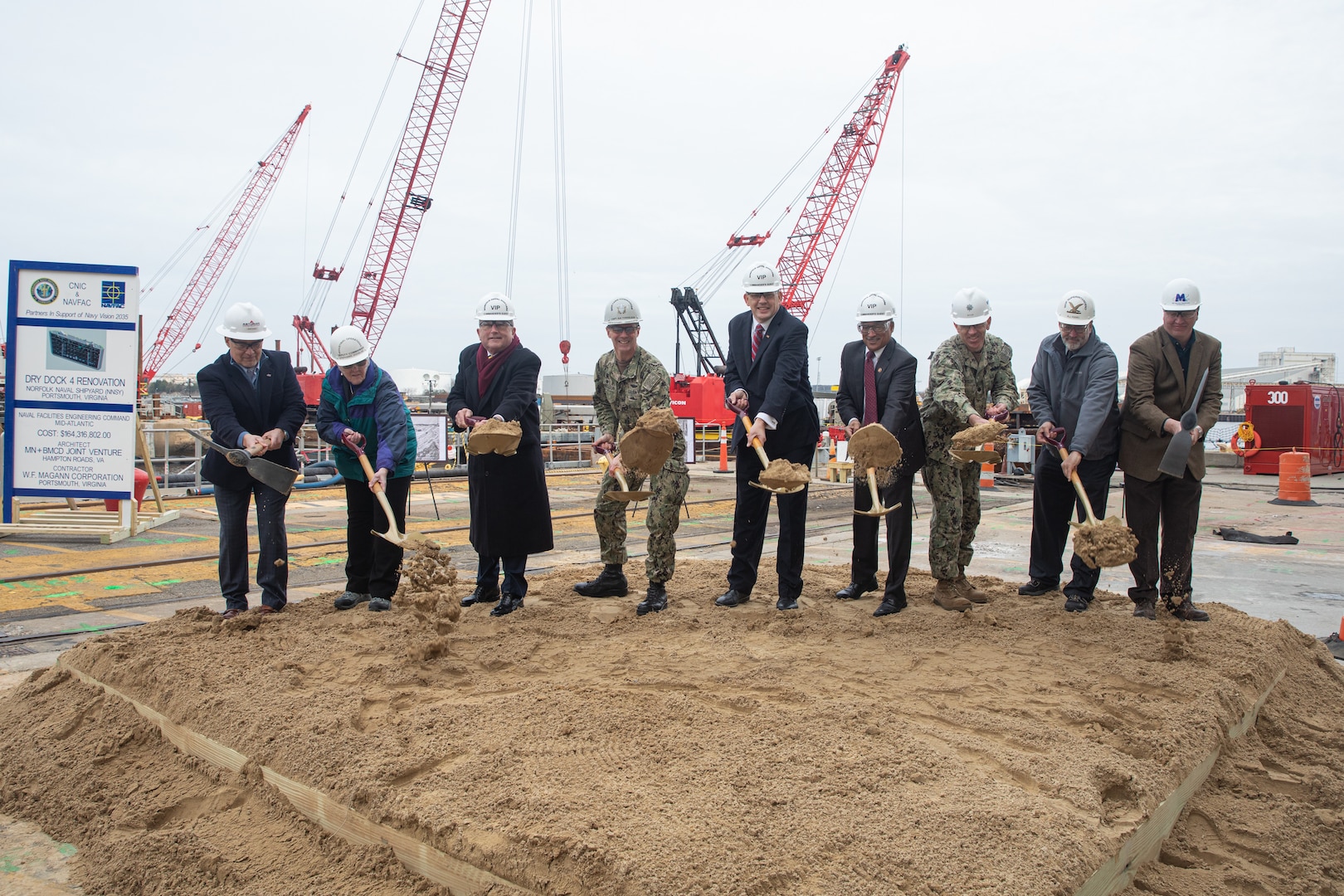 Participants in Norfolk Naval Shipyard’s Dry Dock 4 renovation groundbreaking Jan. 23 include, from left to right: Drew Quiroz, President, Asturian-Consigli JV; Stephanie Douglas, NAVSEA Director of Industrial Operations (SEA 04); John Rowe, Mayor, City of Portsmouth; Capt. Kai Torkelson, Commander, Norfolk Naval Shipyard; James Geurts, Assistant Secretary of the Navy (Research, Development and Acquisition); Congressman Robert “Bobby” Scott, 3rd District of Virginia; Cmdr. William Butler, NAVFAC Public Works Officer, Norfolk Naval Shipyard; Robert Fogel, Project Superintendent, Industrial Facilities and Equipment, Norfolk Naval Shipyard; and Stan Magann, Vice President, W.F. Magann Corporation.