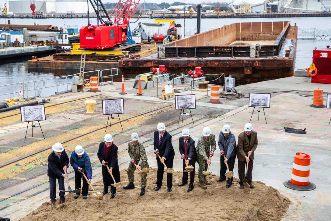 Participants in Norfolk Naval Shipyard’s Dry Dock 4 renovation groundbreaking Jan. 23 include, from left to right: Drew Quiroz, President, Asturian-Consigli JV; Stephanie Douglas, NAVSEA Director of Industrial Operations (SEA 04); John Rowe, Mayor, City of Portsmouth; Capt. Kai Torkelson, Commander, Norfolk Naval Shipyard; James Geurts, Assistant Secretary of the Navy (Research, Development and Acquisition); Congressman Robert “Bobby” Scott, 3rd District of Virginia; Cmdr. William Butler, NAVFAC Public Works Officer, Norfolk Naval Shipyard; Robert Fogel, Project Superintendent, Industrial Facilities and Equipment, Norfolk Naval Shipyard; and Stan Magann, Vice President, W.F. Magann Corporation.