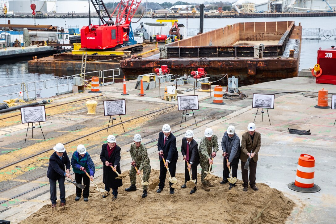 Participants in Norfolk Naval Shipyard’s Dry Dock 4 renovation groundbreaking Jan. 23 include, from left to right: Drew Quiroz, President, Asturian-Consigli JV; Stephanie Douglas, NAVSEA Director of Industrial Operations (SEA 04); John Rowe, Mayor, City of Portsmouth; Capt. Kai Torkelson, Commander, Norfolk Naval Shipyard; James Geurts, Assistant Secretary of the Navy (Research, Development and Acquisition); Congressman Robert “Bobby” Scott, 3rd District of Virginia; Cmdr. William Butler, NAVFAC Public Works Officer, Norfolk Naval Shipyard; Robert Fogel, Project Superintendent, Industrial Facilities and Equipment, Norfolk Naval Shipyard; and Stan Magann, Vice President, W.F. Magann Corporation.