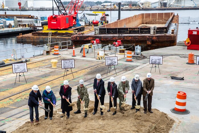 Participants in Norfolk Naval Shipyard’s Dry Dock 4 renovation groundbreaking Jan. 23 include, from left to right: Drew Quiroz, President, Asturian-Consigli JV; Stephanie Douglas, NAVSEA Director of Industrial Operations (SEA 04); John Rowe, Mayor, City of Portsmouth; Capt. Kai Torkelson, Commander, Norfolk Naval Shipyard; James Geurts, Assistant Secretary of the Navy (Research, Development and Acquisition); Congressman Robert “Bobby” Scott, 3rd District of Virginia; Cmdr. William Butler, NAVFAC Public Works Officer, Norfolk Naval Shipyard; Robert Fogel, Project Superintendent, Industrial Facilities and Equipment, Norfolk Naval Shipyard; and Stan Magann, Vice President, W.F. Magann Corporation.