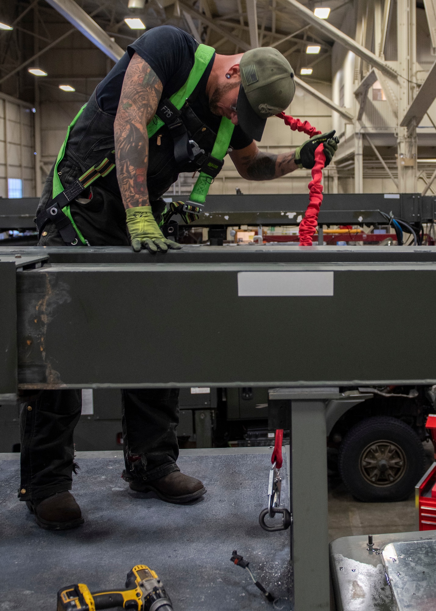 Jessie Mauldin, 673d Logistics Readiness Squadron heavy mobile equipment mechanic, evaluates the new connection between a fall-protection safety harness tether and a deicing truck at Joint Base Elmendorf-Richardson, Alaska, Jan. 22, 2019. The modification involves strategically attaching four eyelets to the top of each truck so mechanics can attach a mobile safety harness. Mauldin has taken steps to push his innovation to all heavy mobile equipment maintenance shops Air Force-wide.