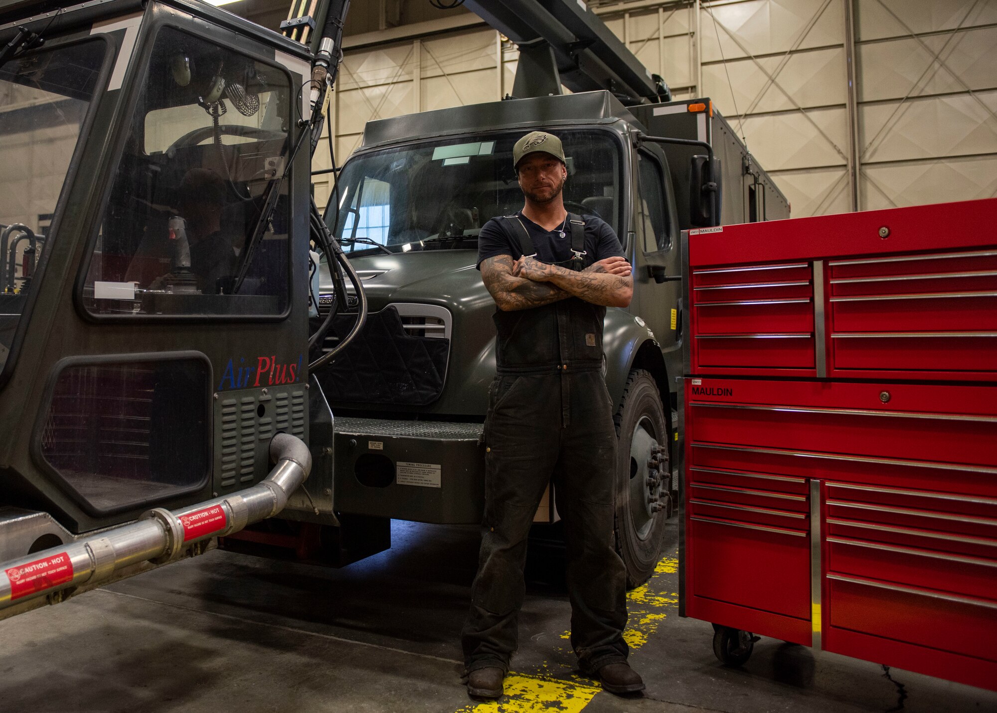 Jessie Mauldin, 673d Logistics Readiness Squadron heavy mobile equipment mechanic, poses for a photo next to a newly modified deicing truck at Joint Base Elmendorf-Richardson, Alaska, Jan. 22, 2019. The modification involves strategically attaching four eyelets to the top of each truck so mechanics can attach a mobile safety harness. Mauldin has taken steps to push his innovation to all heavy mobile equipment maintenance shops Air Force-wide.