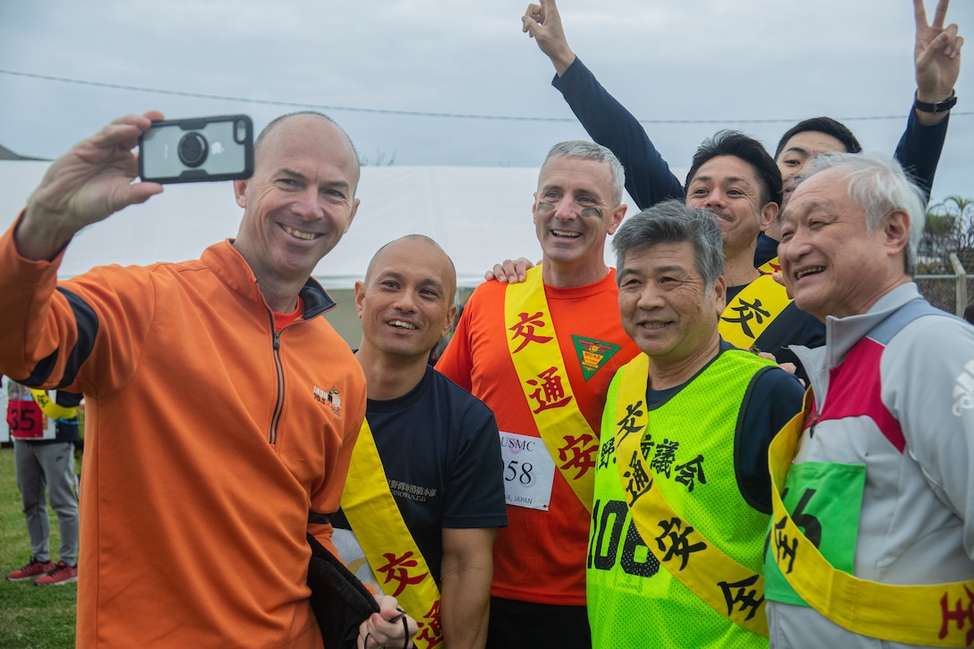 U.S. Marine Corps Col. David Steele, Marine Corps Air Station (MCAS) Futenma commanding officer, and Col. Vincent J. Ciuccoli, Headquarters and Support Battalion commanding officer, gather with participants for a photo before the 43rd Annual Ginowan Safety Relay at MCAS Futenma, Okinawa, Japan, Jan. 18, 2020. The relay race was held to raise awareness for road safety and to build the relationship between the U.S. military and local Okinawa communities. (U.S. Marine Corps photo by Lance Cpl. Zachary R. Larsen)