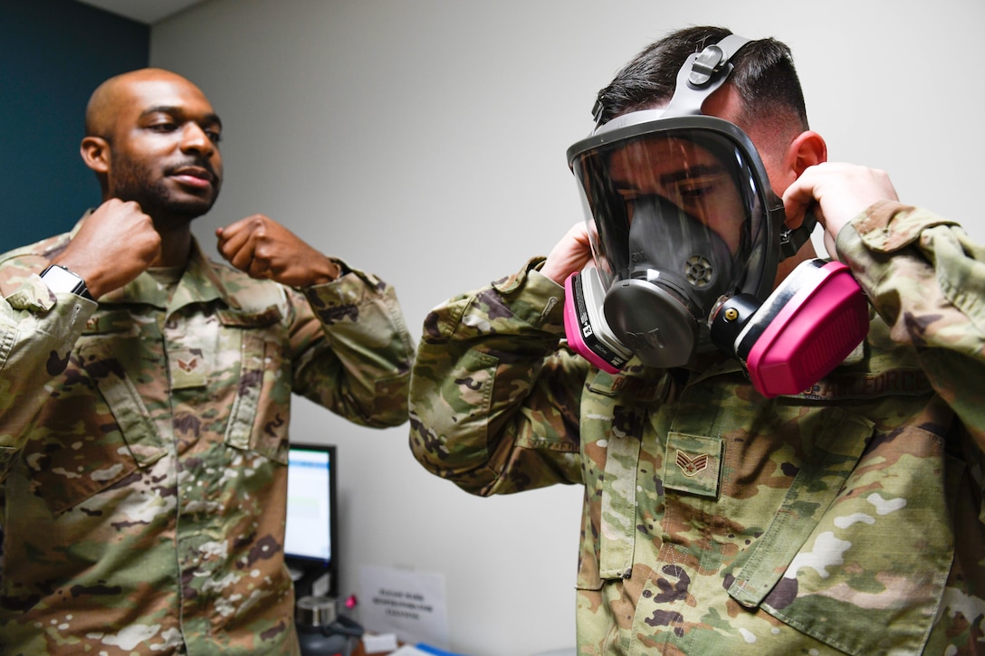 U.S. Air Force Senior Airman Gregory Rackley, 56th Occupational Medicine Readiness Squadron bioenvironmental engineering technician, instructs Senior Airman Joseph Bowden, 62nd Aircraft Maintenance Unit crew chief, on the procedure to tighten a gas mask during a fit test at Luke Air Force Base, Arizona, Jan. 14, 2020. The technicians administer fit tests for individuals who are deploying, and individuals perform various movements while wearing the gas mask to test how well it fits to their face. Bioenvironmental engineering’s mission is to provide reliable health risk expertise to optimize human performance and prevent adverse health effects of Airmen. (U.S. Air Force photo by Airman 1st Class Brooke Moeder)