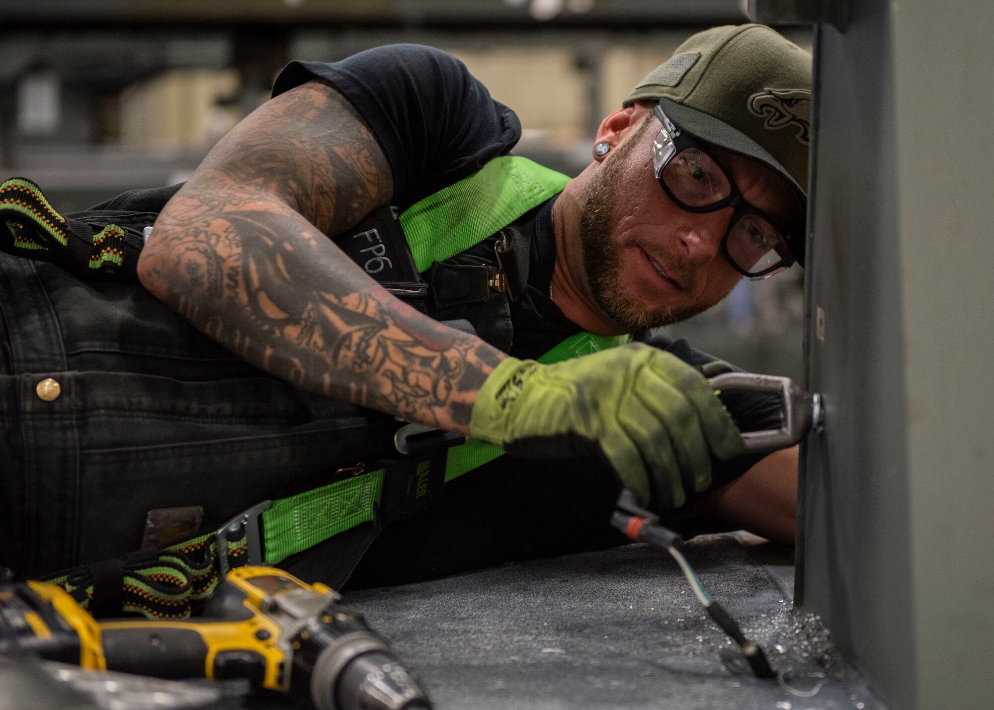 Jessie Mauldin, 673d Logistics Readiness Squadron heavy mobile equipment mechanic, attaches an eyelet on top of a deicing truck to tether a fall-protection safety harness at Joint Base Elmendorf-Richardson, Alaska, Jan. 22, 2019. The modification involves strategically attaching four eyelets to the top of each truck so mechanics can attach a mobile safety harness. Mauldin has taken steps to push his innovation to all heavy mobile equipment maintenance shops Air Force-wide.