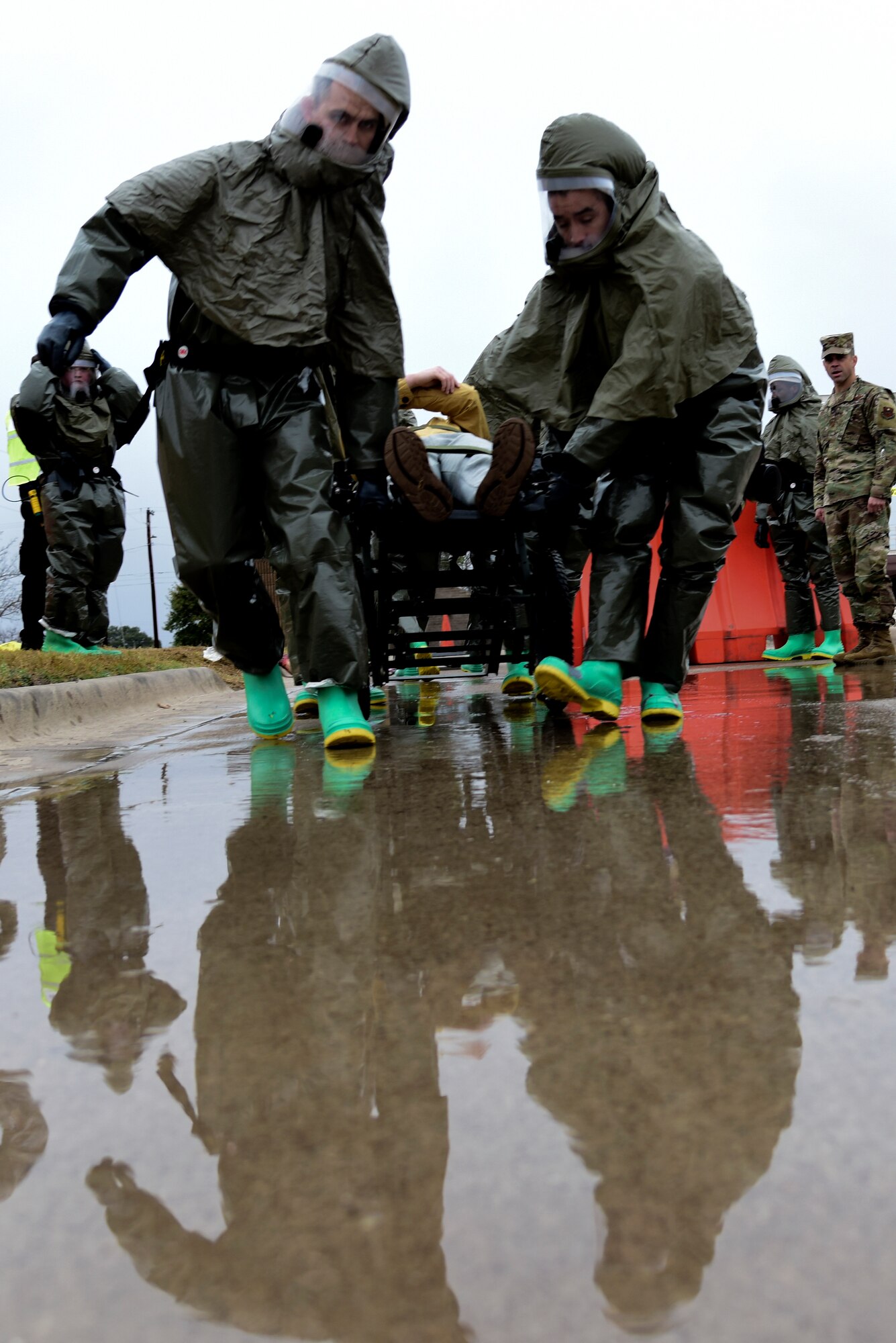 47th Medical Group medics wearing powered, air-purified respirator suits roll a stretcher carrying a volunteer patient to the in-place patient decontamination during the Ready Eagle exercise at Laughlin Air Force Base, Texas, Jan. 17, 2020. (U.S. Air Force photo by Senior Airman Anne McCready)