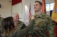 Newly appointed U.S. Army Reserve Chaplain (1st Lt.) Gabriel Pech, 7th Mission Support Command, receives the Army Chaplain cross from his wife, Hannah, while the U.S. Army Chief of Chaplains, Chaplain (Maj. Gen.) Thomas L. Solhjem looks on, during a pinning ceremony held at the Daenner Kaserne Chapel in Kaiserslautern, Germany on January 22, 2020. Pech was the first U.S. Army Reserve officer to complete the Chaplain Candidate Program in Europe.