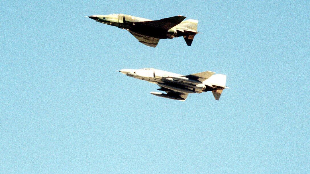 A left side view of two RF-4C Phantom II aircraft in flight