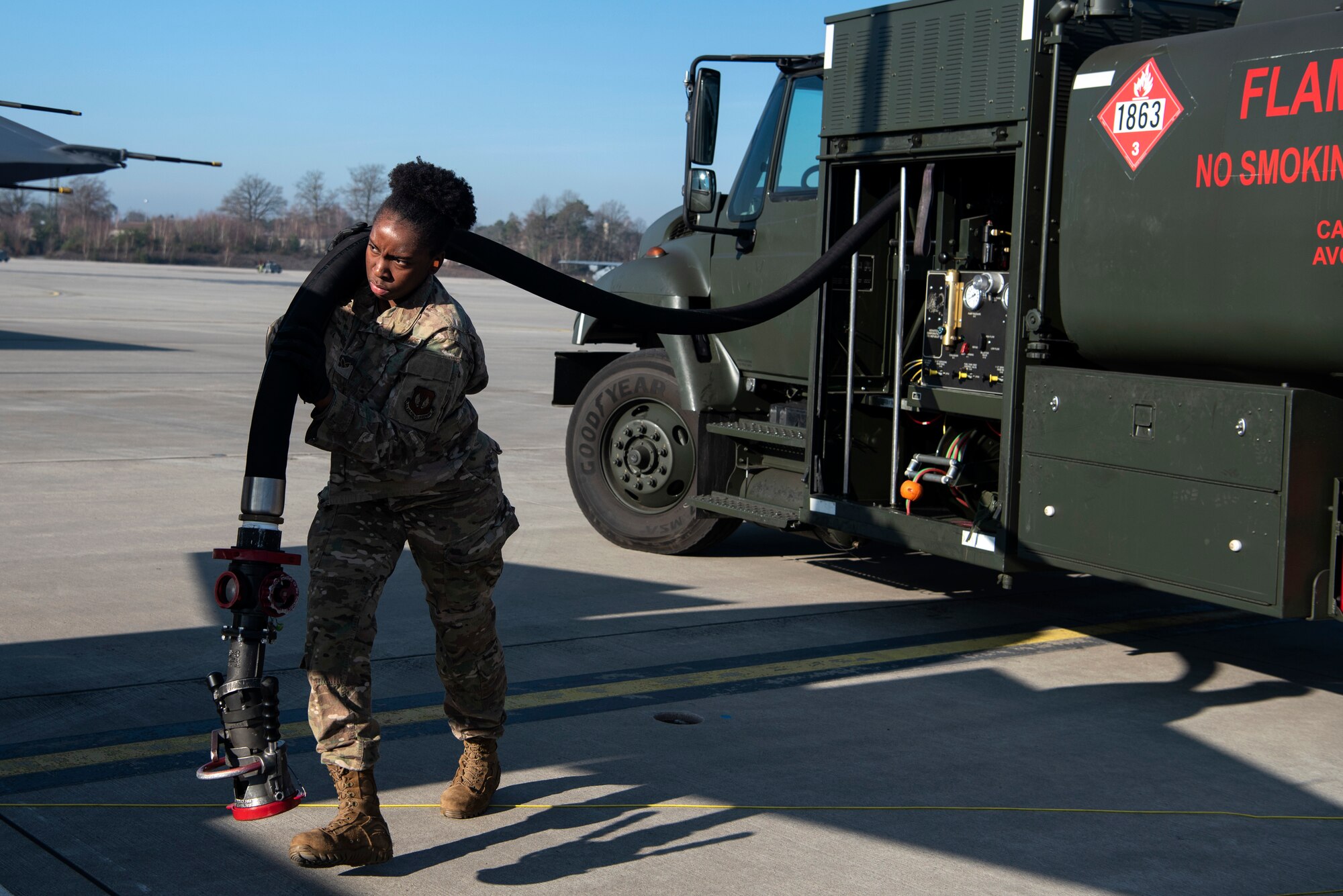 U.S. Air Force Senior Airman Aaliyah Tucker, 52nd Logistics Readiness Squadron fuels facilities operator, carries a fuel hose on the flightline at Ramstein Air Base, Germany, Jan. 22, 2020. Tucker participated in an Agile Combat Employment exercise to ensure wing readiness and deter aggressors. A small team of 52nd Fighter Wing Airmen shipped cargo, loaded munitions, and refueled F-16 Fighting Falcons while participating in the exercise. (U.S. Air Force photo by Airman 1st Class Valerie Seelye)